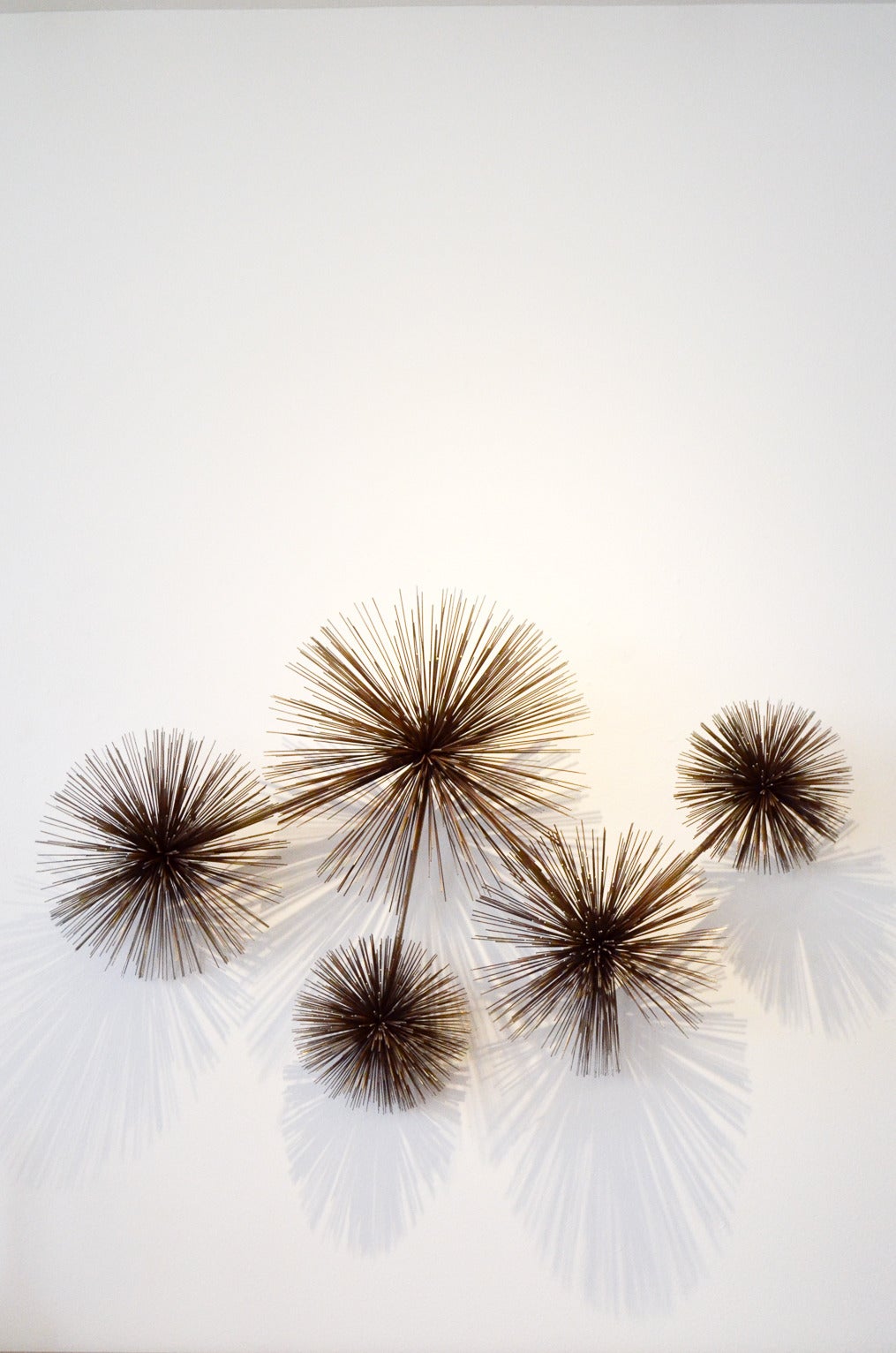 Beautiful and rare brutalist wall sculpture with five brown gilt patinated steel pom pom or sea-urchins on straight iron rods. Signed 1979. By Jerry Fels (1919-2007) and Curtis Freiler (1910-), two designers for the name of Curtis Jere who designed