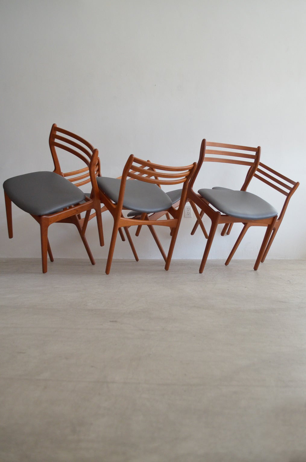 Sculptural and rare set of six teak dining chairs by P.E. Jørgensen for Farso Stolefabrik. Newly reupholstered with easy care grey naugahyde. Wood has been restored and is in perfect showroom condition. Beautiful sculpted and rounded ladder backs