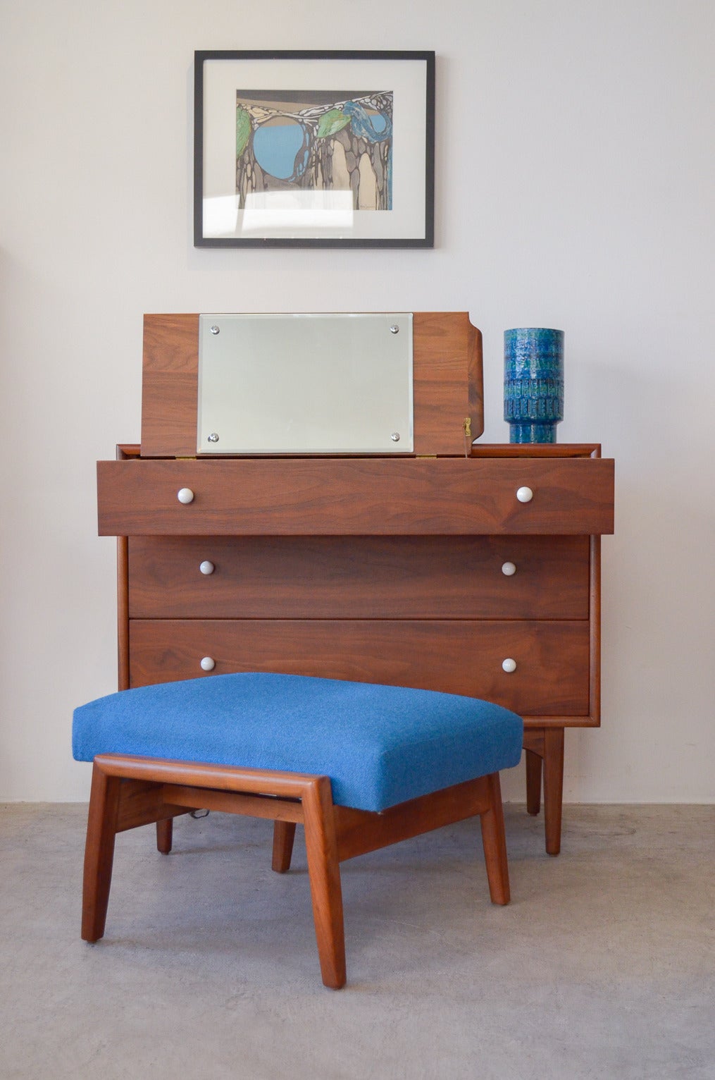 Beautiful three-drawer dresser with hidden vanity by Kipp Stewart for Drexel. Inside top drawer has the original flip-top vanity with original glass and a sliding milk glass shelf.

The entire mechanism is also removable if you don't desire the