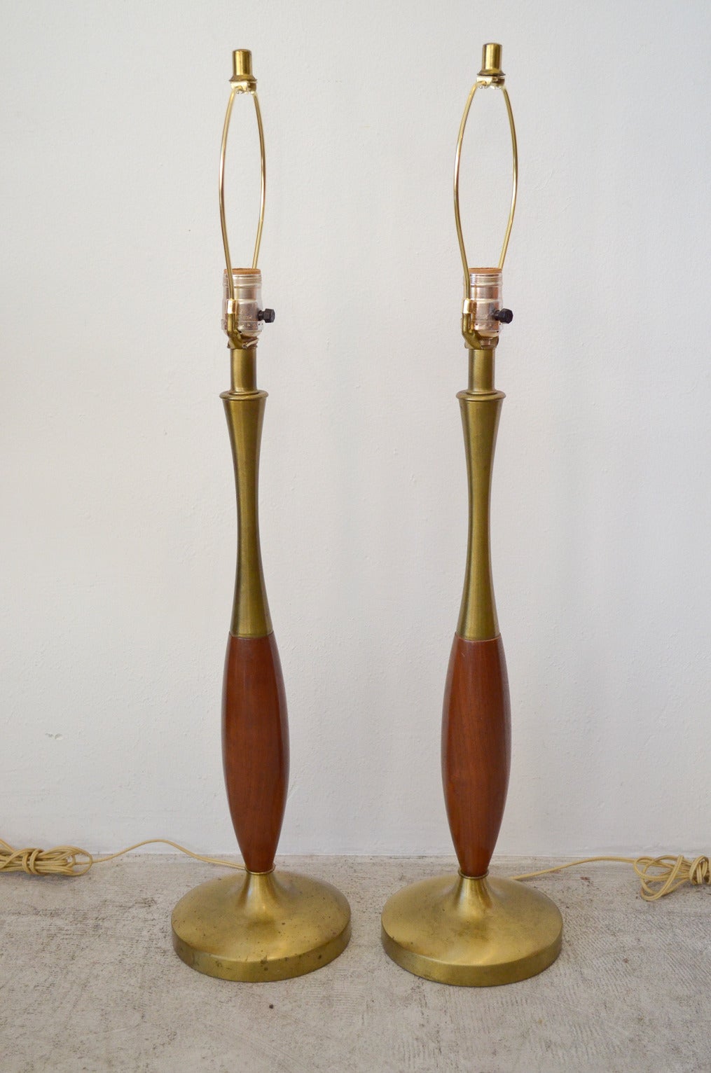 Matching pair of Patinated Brass and Walnut Tapered Lamps by Navis and Smith, Chicago, IL.  Original wiring, perfect working condition, still retain manufacturers label on the base.

Shades NOT INCLUDED, shown for scale.  Inquire if you would like