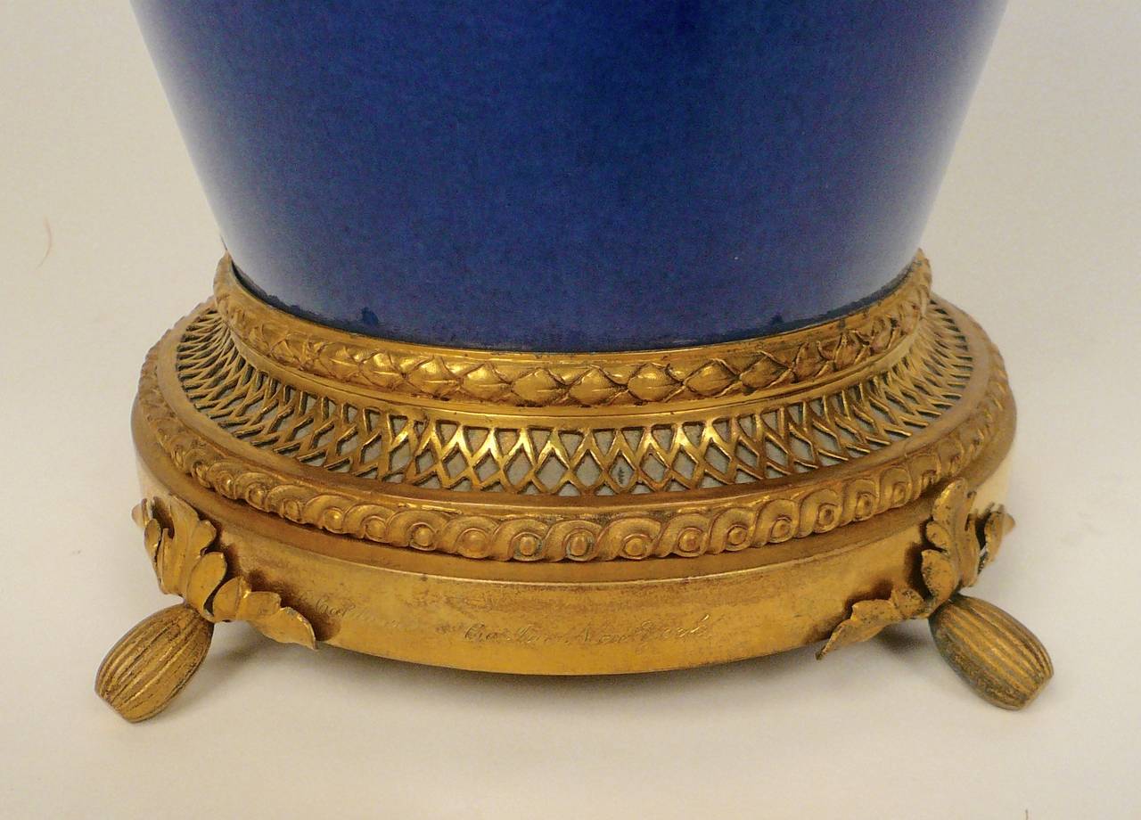 This beautiful mottled blue porcelain lamp, mounted in gilt bronze with four lights is signed Edward F. Caldwell (see photo).
