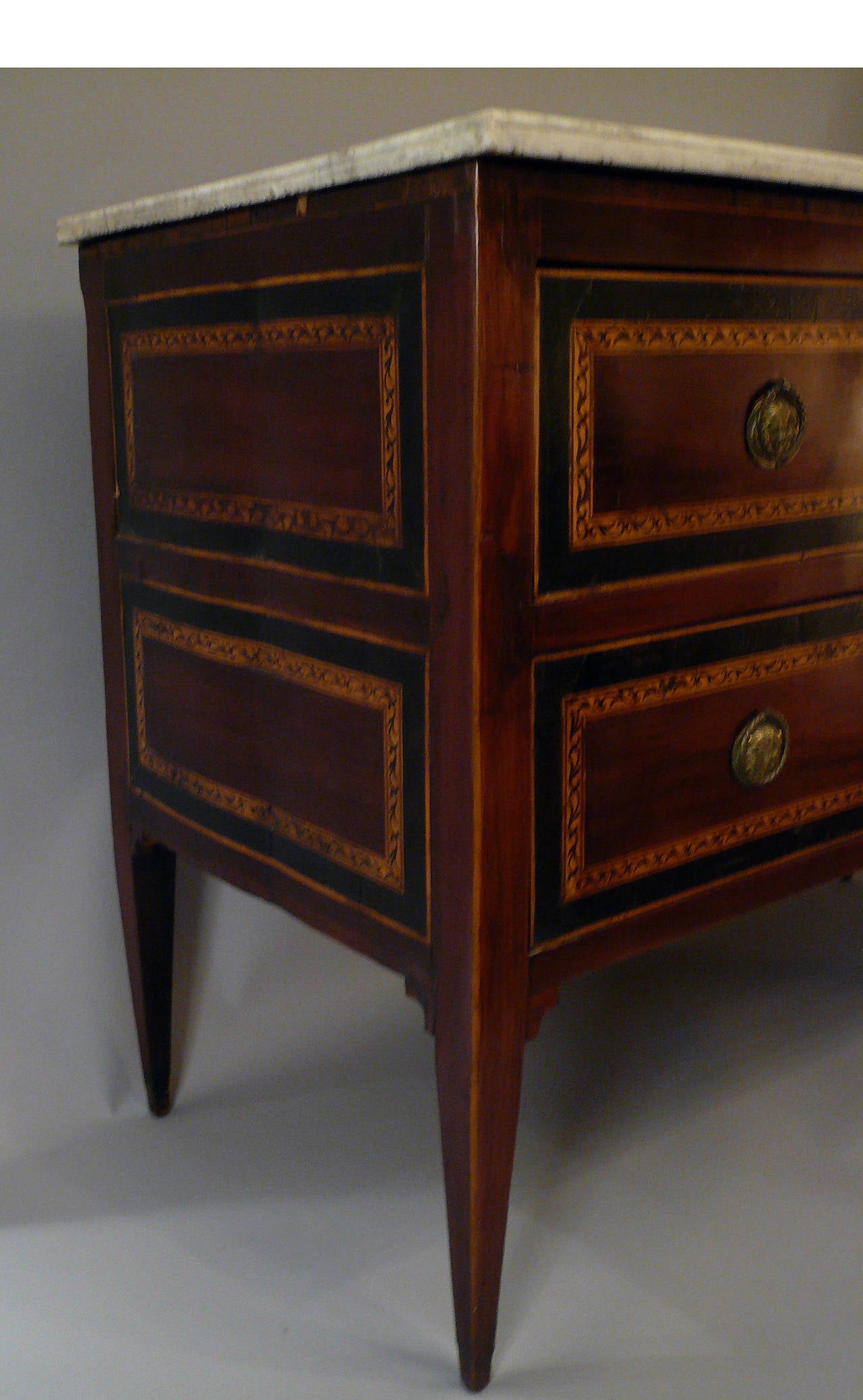 Attributed to Maggiolini, this marble-top two-drawer commode is inlaid with mahogany ebony and satinwood.
