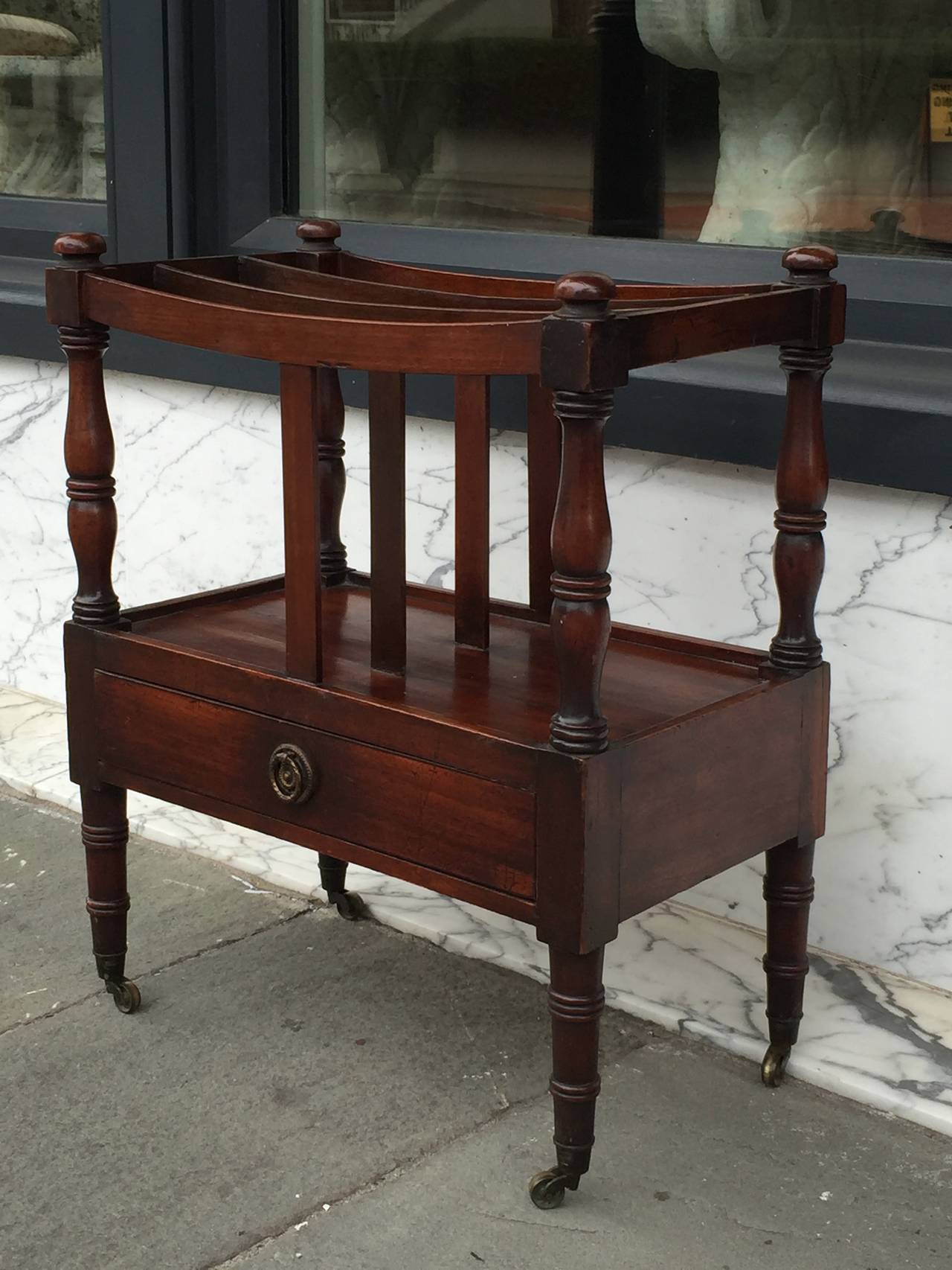 English mahogany single drawer Canterbury with turned leg on brass casters.  Very nice small size.