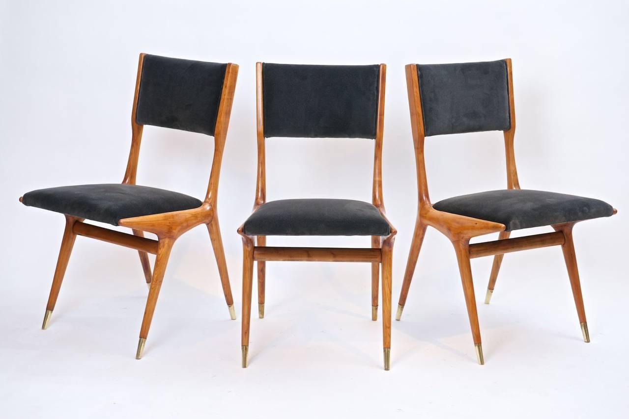 Dining chairs by Carlo di Carli.

European cherrywood, upholstered in charcoal grey velvet. Brass sabots.