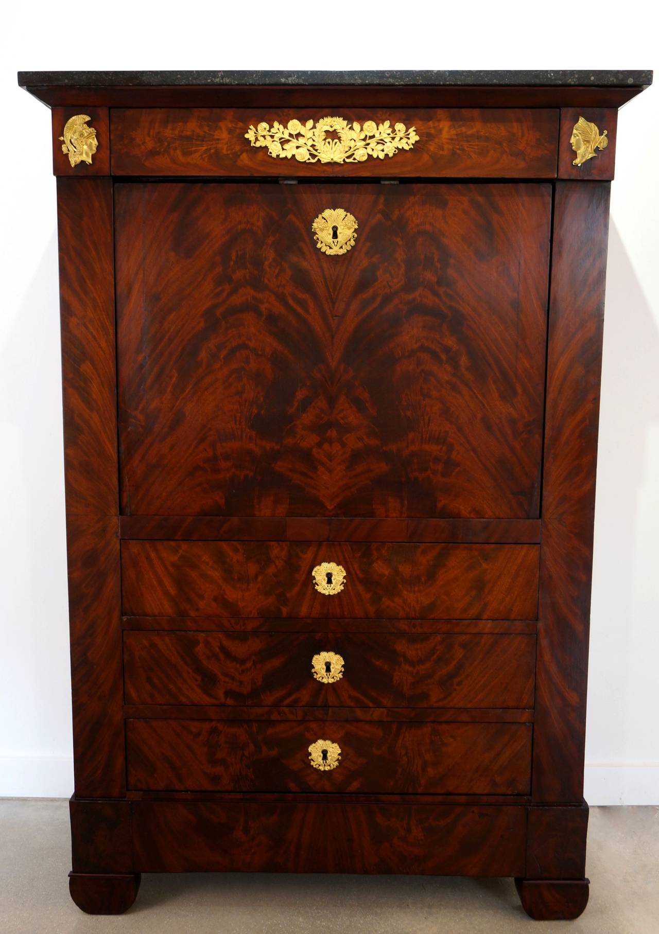 This secretaire a abattant is the in French Empire style and is veneered in Cuban acajou mahogany, with bronze doré mounts and a gray Saint Anne marble top. 

Dimensions Closed:
Height: 56.5 in. (143.51 cm)
Width: 38 in. (96.52 cm)
Depth: 15.75 in.