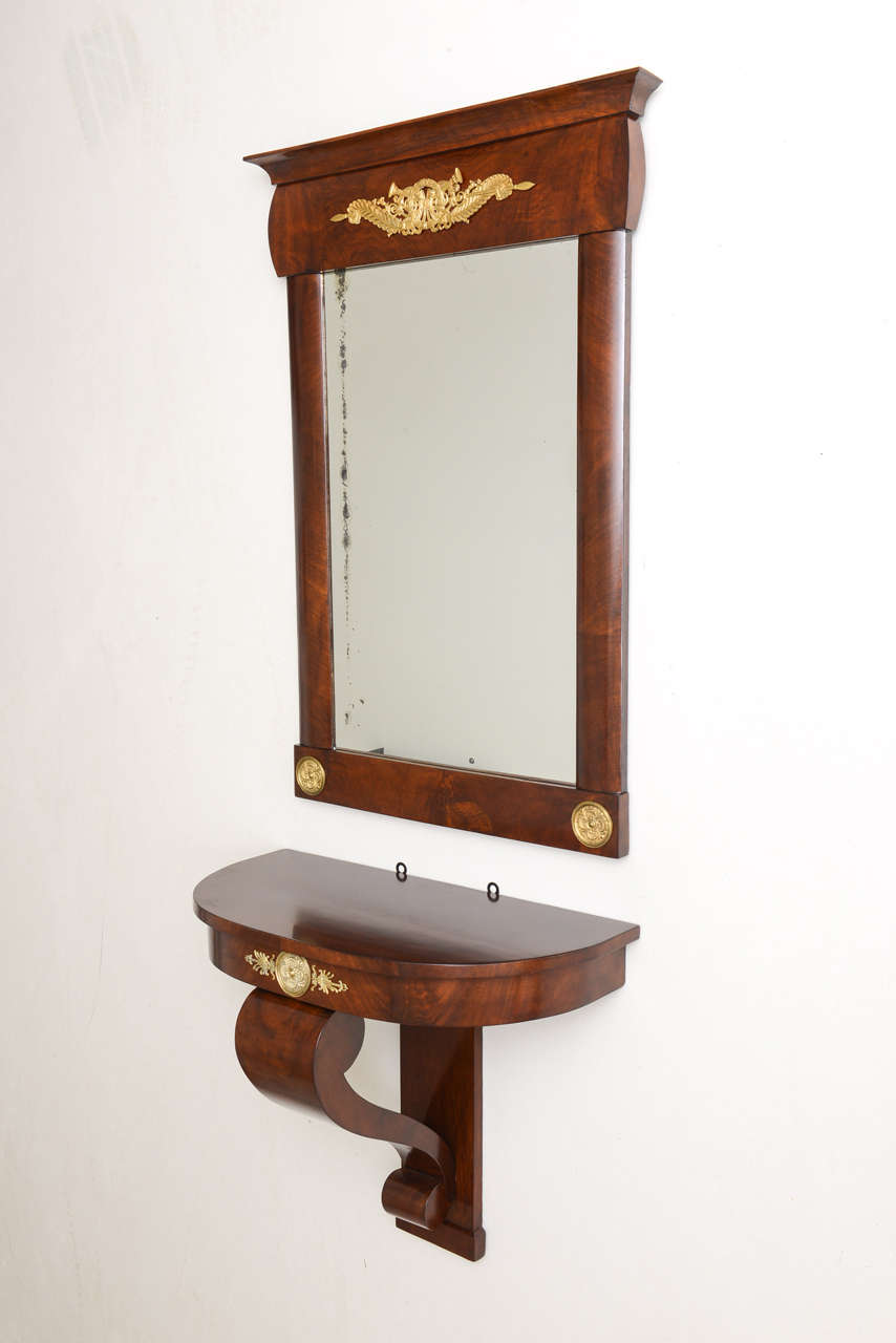 Stylish 19th century Austrian Biedermeier mirror with a demilune bracketed wall shelf. 

Made with mahogany veneers and bronze doré´ mounts. 

The wall shelf measures 25