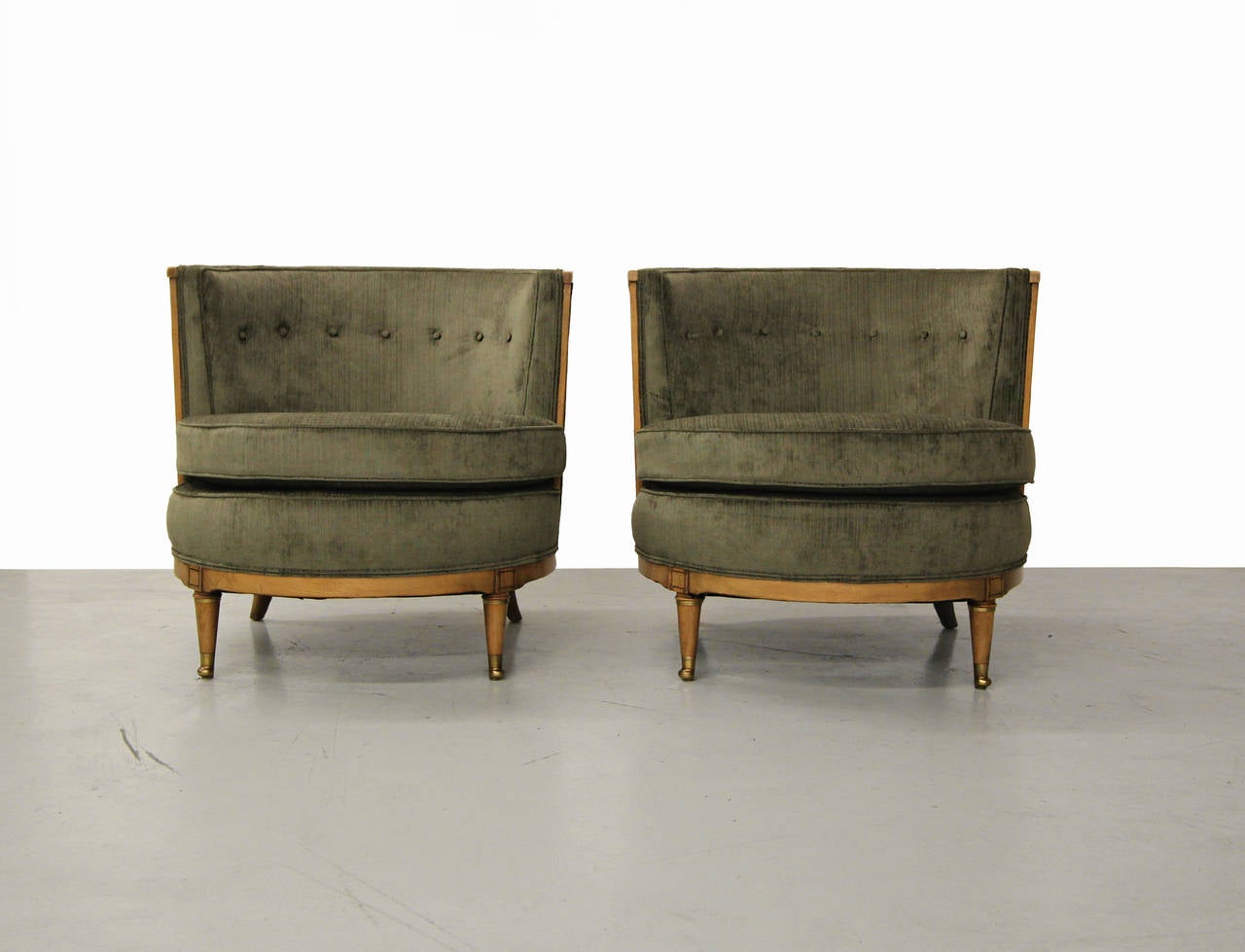 Beautiful and rare pair of barrel back occasional chairs by Mastercraft furniture.  These chairs have gorgeous wood trim and bases with brass feet and details on the legs.  The back legs are set at a bit of an angle giving these guys a beautiful