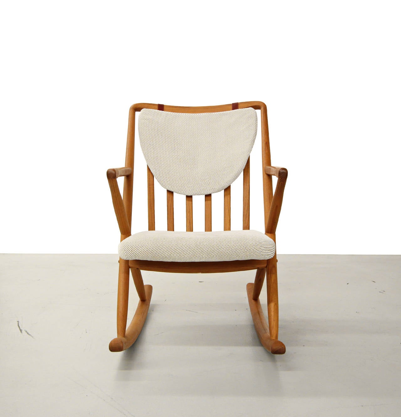 Mint condition Danish teak rocker in the manner of Frank Reenskaug for Bramin.  Perfect nursery or reading corner rocker.  Neutral cream/beige stripe fabric with cognac leather strap attachments.