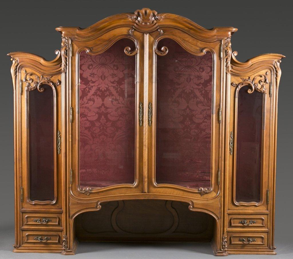 Monumental continental carved walnut buffet cabinet. It is late 19th-early 20th century, and possibly French, with a bit of Art Nouveau influence. This Rococo Revival style carved hardwood cabinet with floral brass hardware, is a huge and imposing
