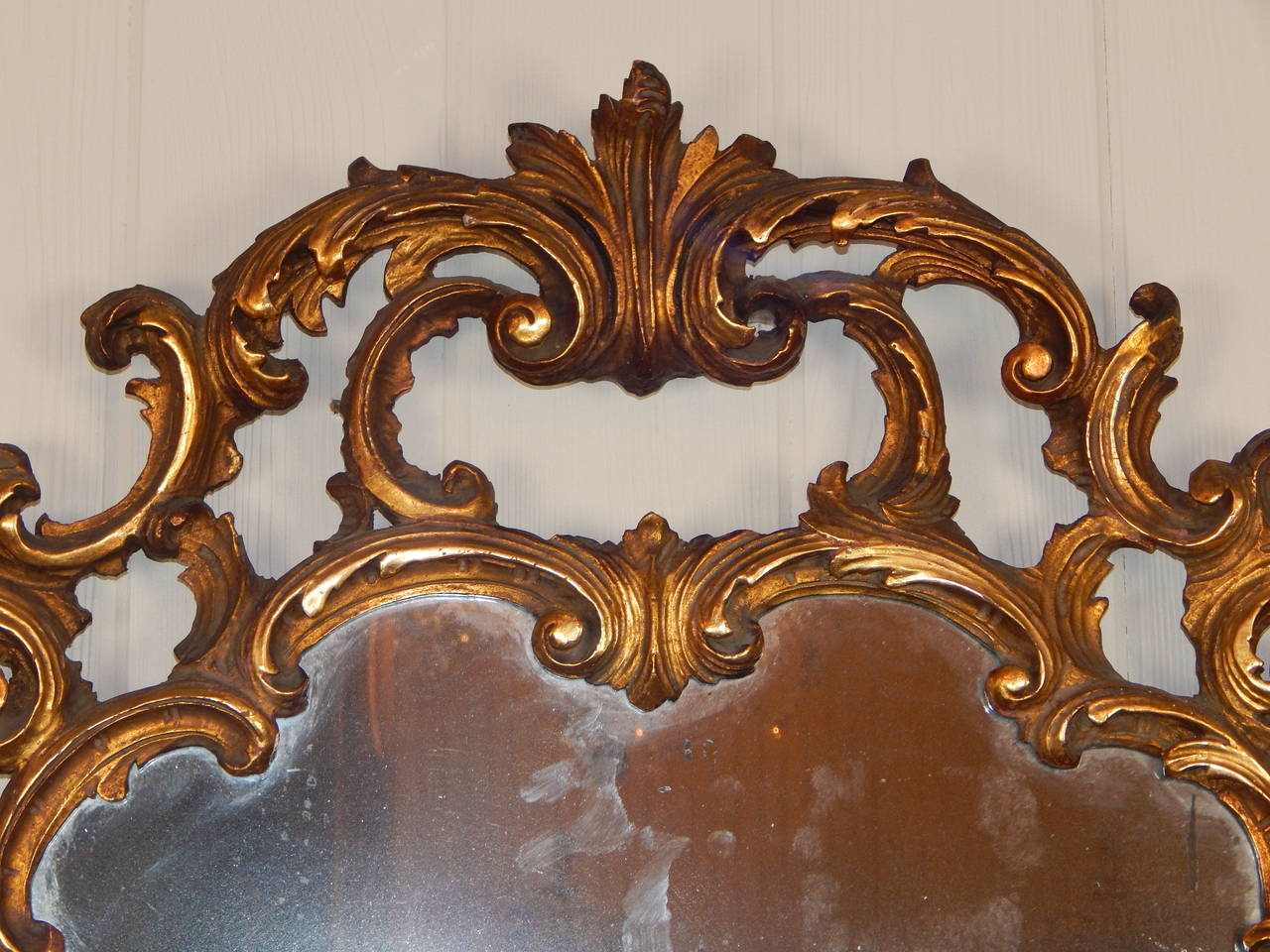 A finely carved and gilded antique English mirror with original glass.