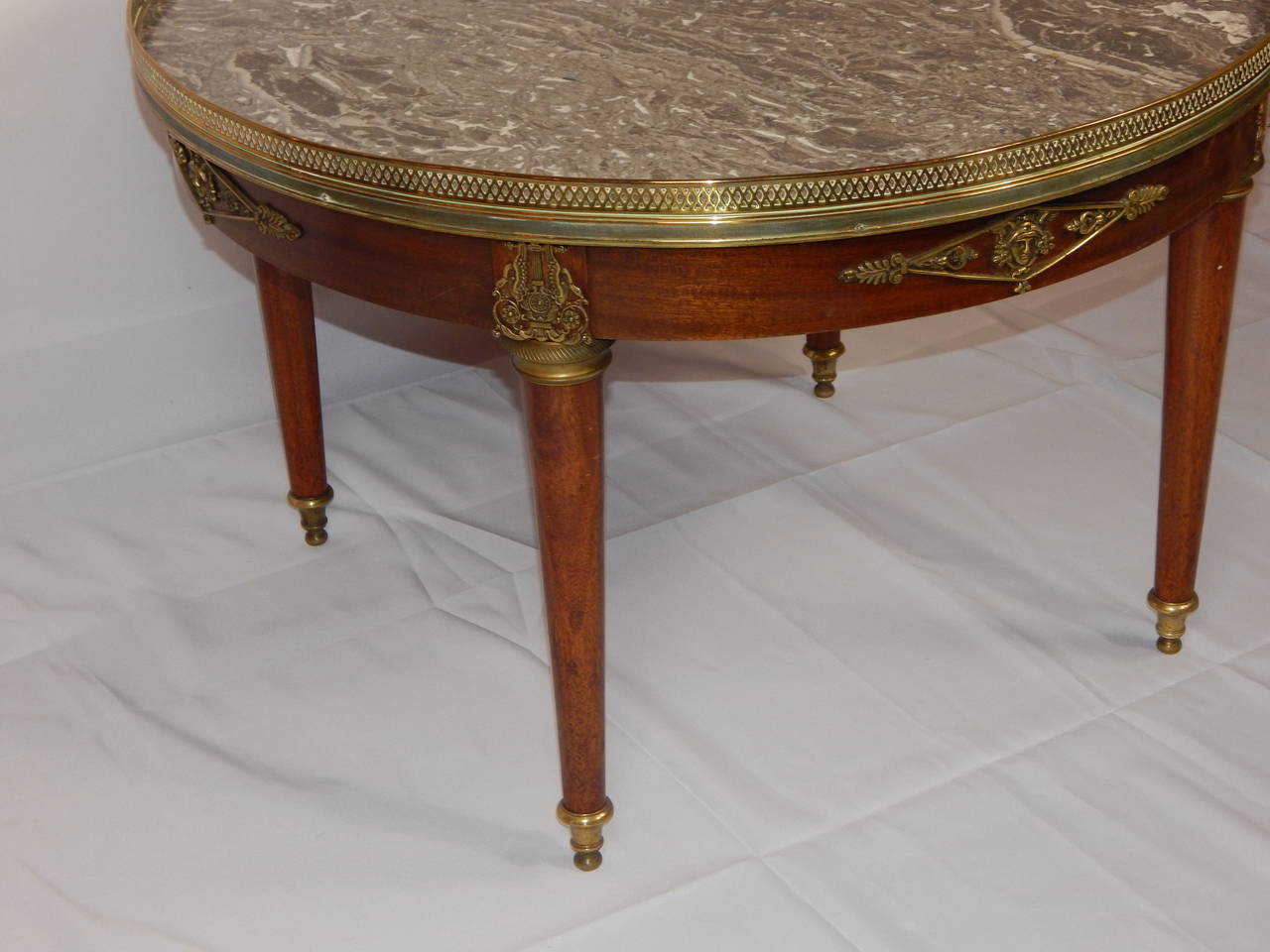 Good quality Empire style bronze mounted mahogany coffee or cocktail table,
having a grey mottled marble top inset, surrounded by a pierced brass gallery.