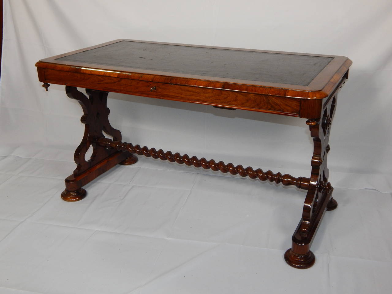 Mahogany and Rosewood writing table with inset leather top,
with a spool stretcher. One center drawer, with the lock stamped
Hobson & Co. London.