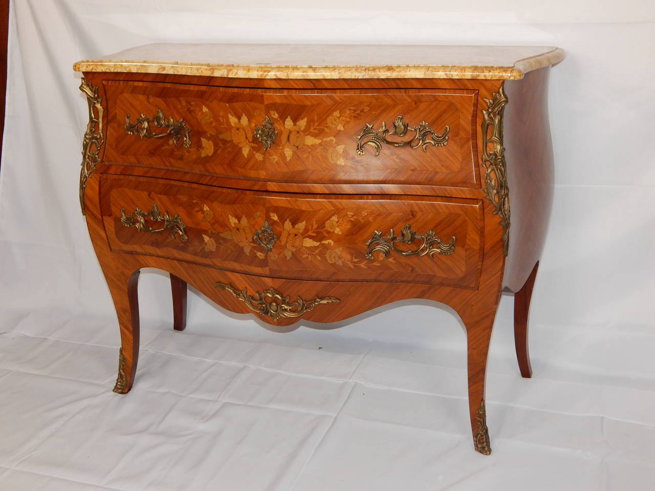 Marquetry inlaid marble-top two-drawer commode with bronze mounts, 
and a serpentine front.
