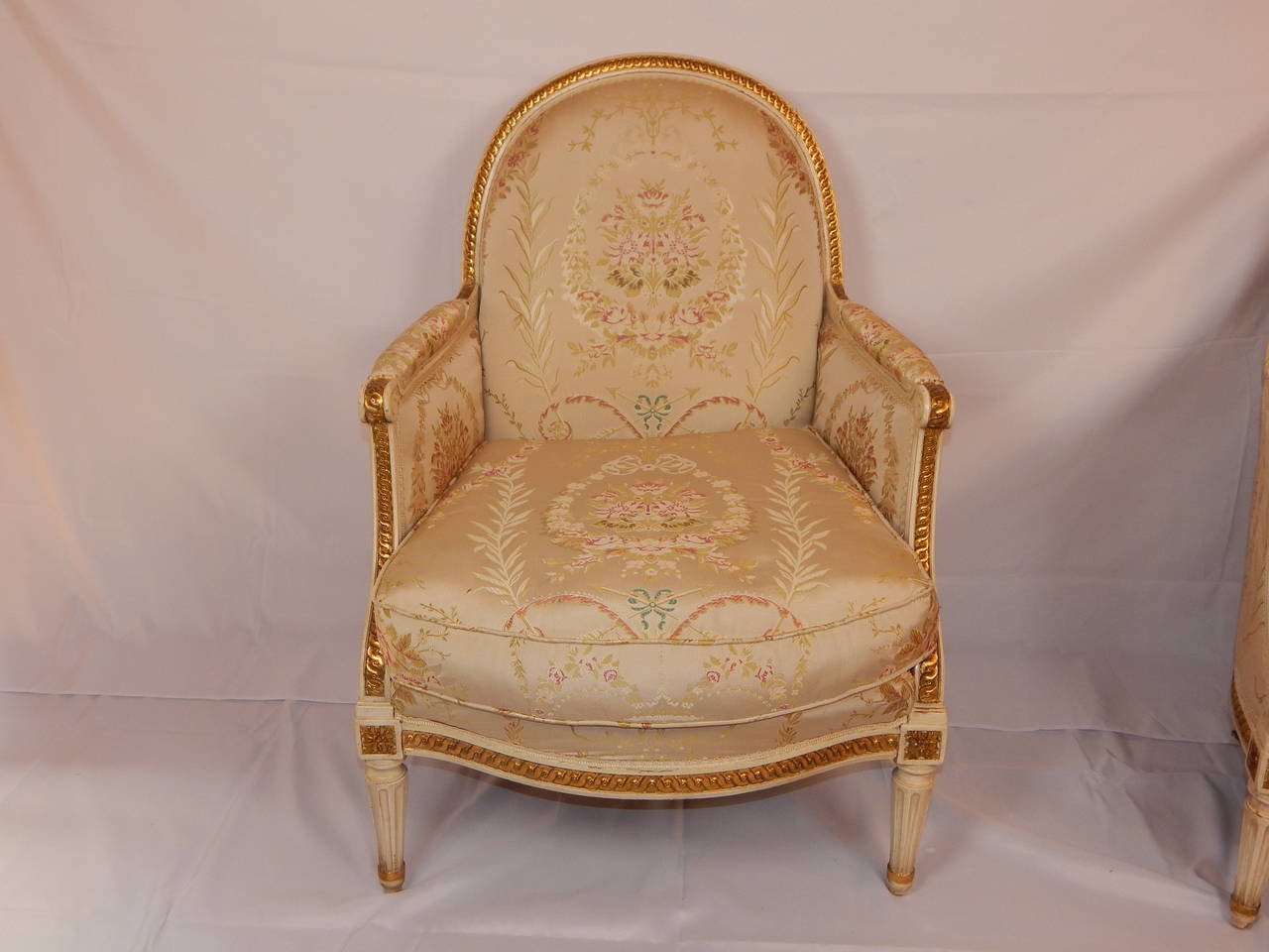 A good pair of Louis XVI style bergère with down cushions, and silk upholstery.