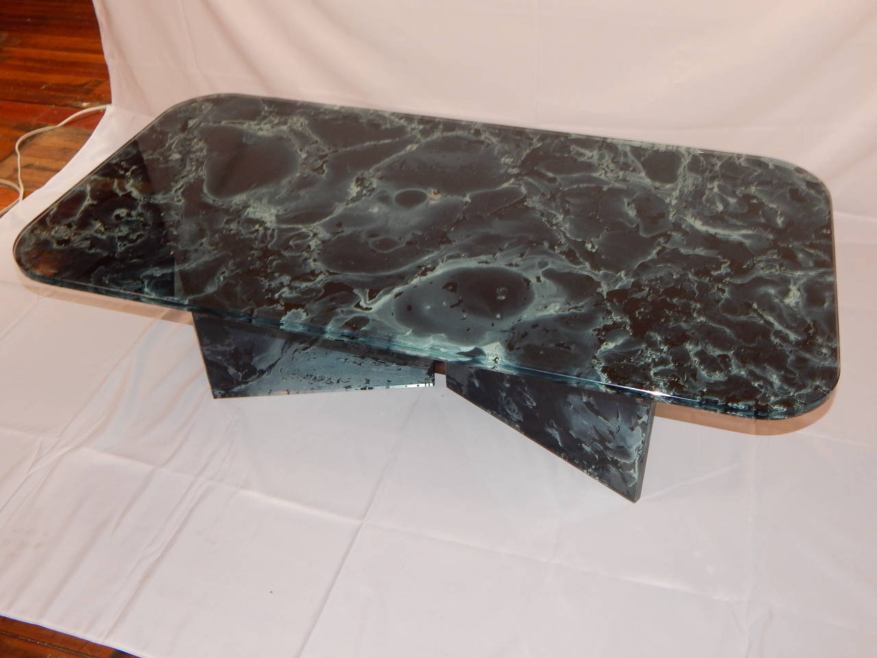 A beautifully marbleized painted modern glass coffee or cocktail table.
Painted on the inside, of two laminated pieces of glass.