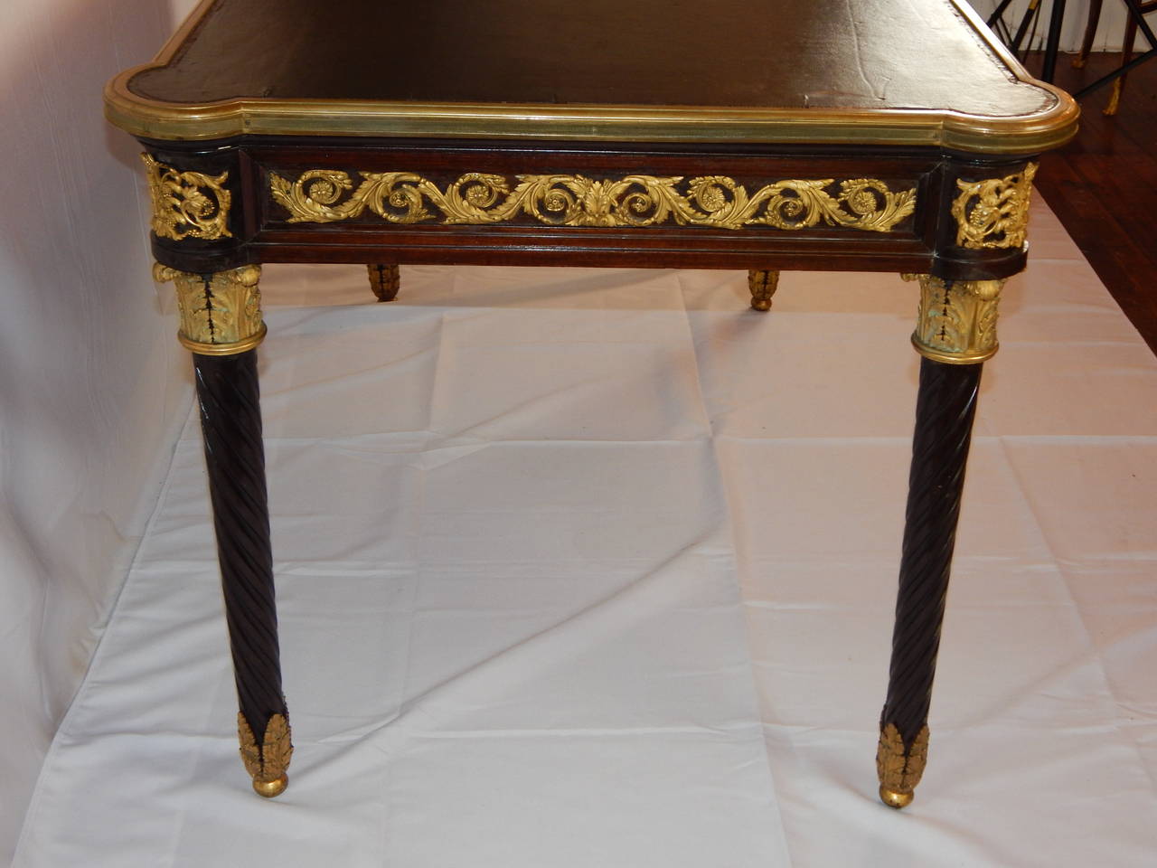 A fine quality Louis XVI style bronze mounted writing table, or bureau plat, with a single long drawer, rope turned legs, and leather top.