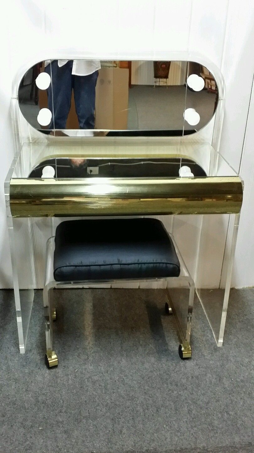 An unusual mid century modern style Lucite dressing table, or vanity, with lights on the mirror, with matching bench on wheels.