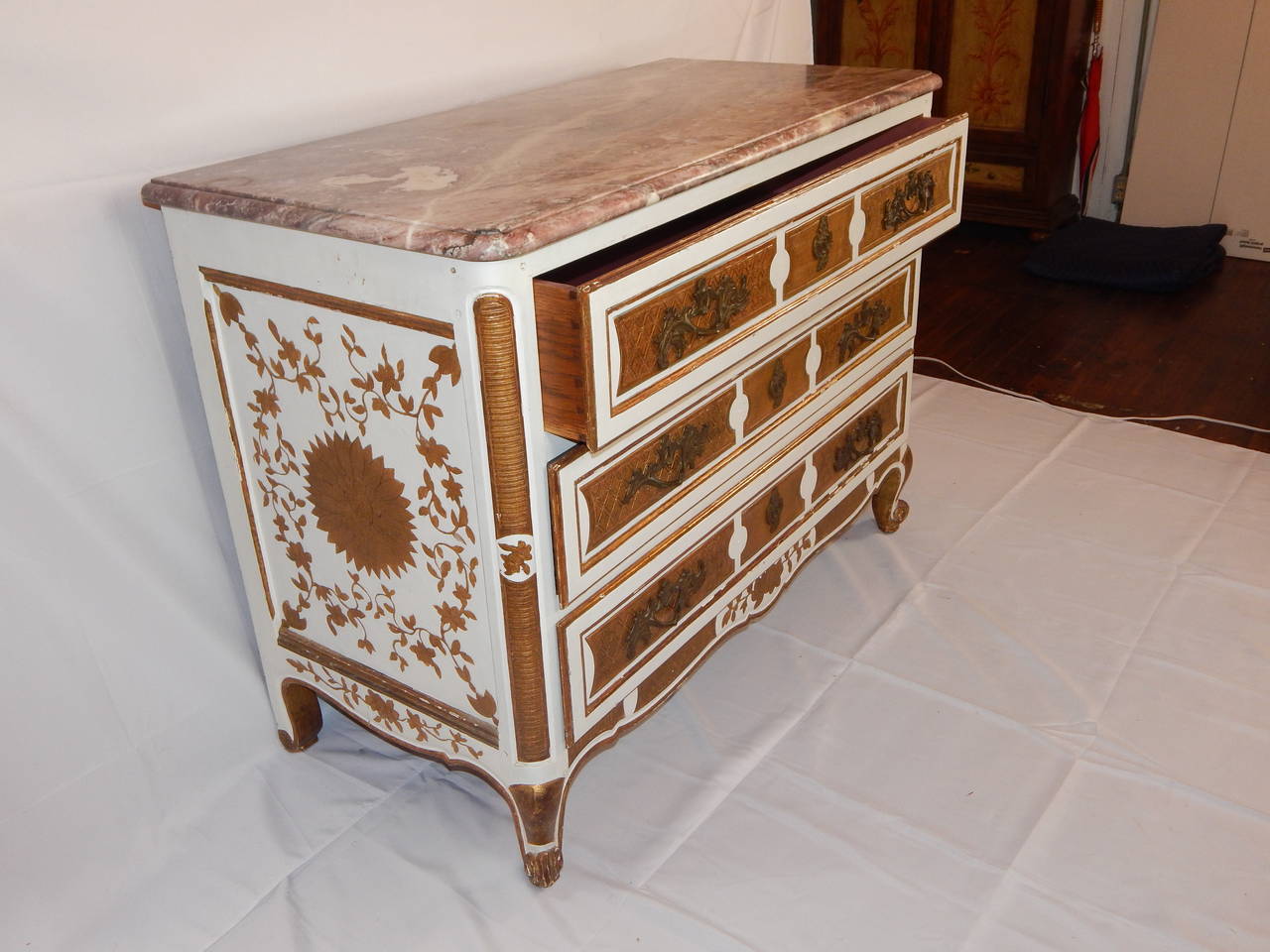 A lovely Louis XV style marble top three drawer commode, with cabriole legs
and pegged construction. Painted white with gilt floral decoration throughout.