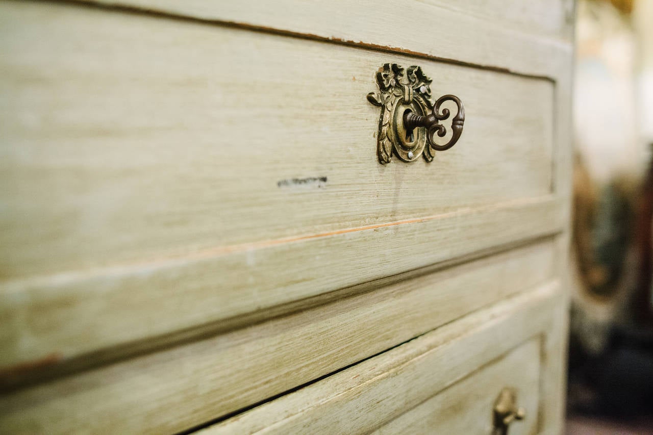 This 18th Century Painted French Chest has a pale green finish with a gold stone top.  It has four drawers with brass pulls and escutcheons.