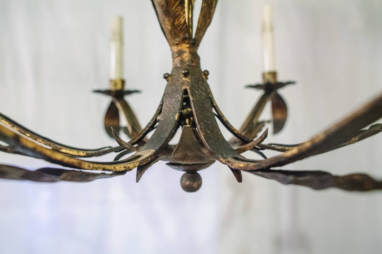This 20th Century Spanish Tole Chandelier features a leaf design over a twisted center structure with six leaf shaped arms radiating out.  The matching original canopy is included. This chandelier has been newly rewired.