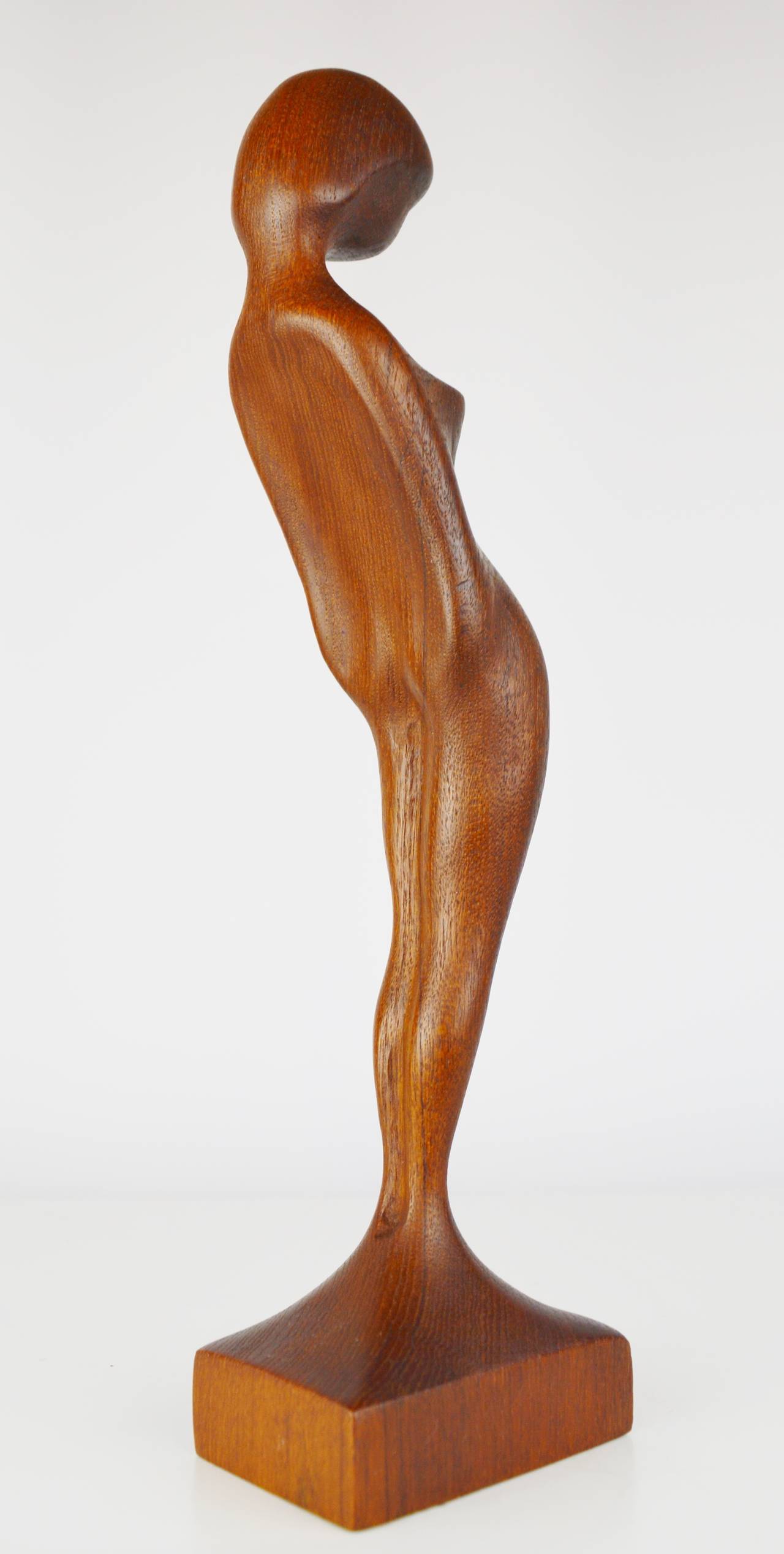 Beautiful and whimsical abstracted female modest nude sculpture made from a single piece of teak and which is lovely from every angle. A rare piece handcrafted by Danish sculptor, Arne Basse, best known for his comical teak sculptures of vikings.