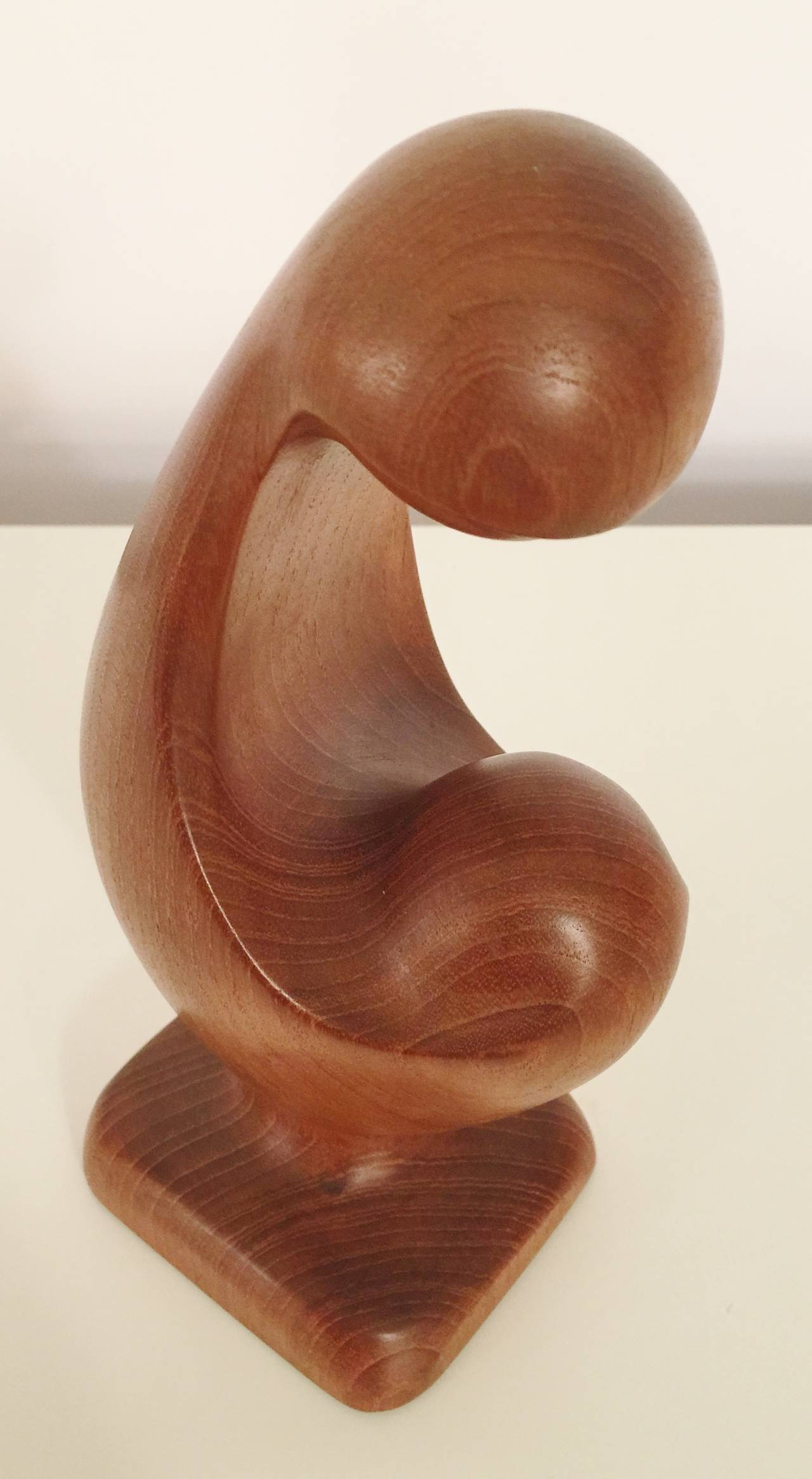This charming abstracted carving of a mother and child by Simon Randers dates from the 1960s and is iconic of his style and has a lovely warm patina. Lovely from every perspective and carved from a single piece of old growth teak, branded on the