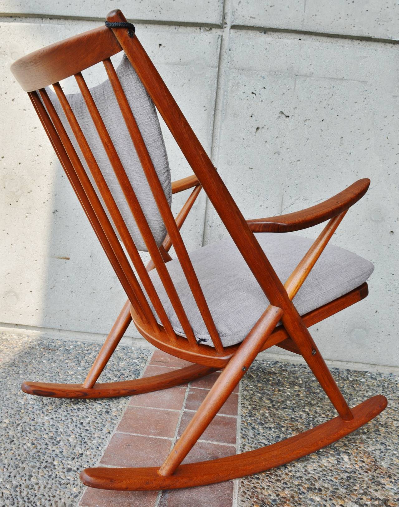 This stellar and iconic Danish Modern teak rocking chair is a beauty! Designed by Frank Reenskaug for Bramin.  Restored and reupholstered with new strapping, 25 year foam and plush light gray textured upholstery, it has the loveliest lines and