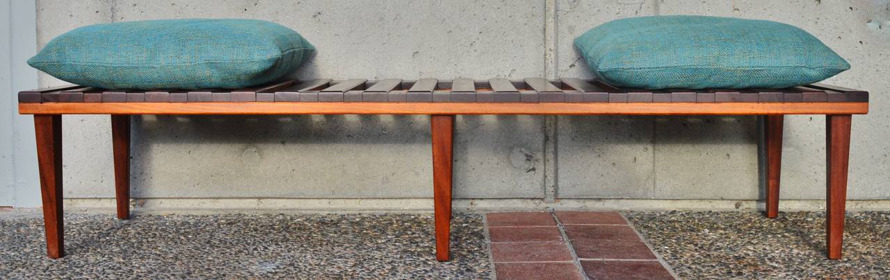 This impeccable Mid-Century Modern solid teak, rosewood and mahogany slat bench or coffee table is beautifully constructed with raised wood slats with recessed wood spacers across horizontal wood slats with fine craftsmanship throughout. The