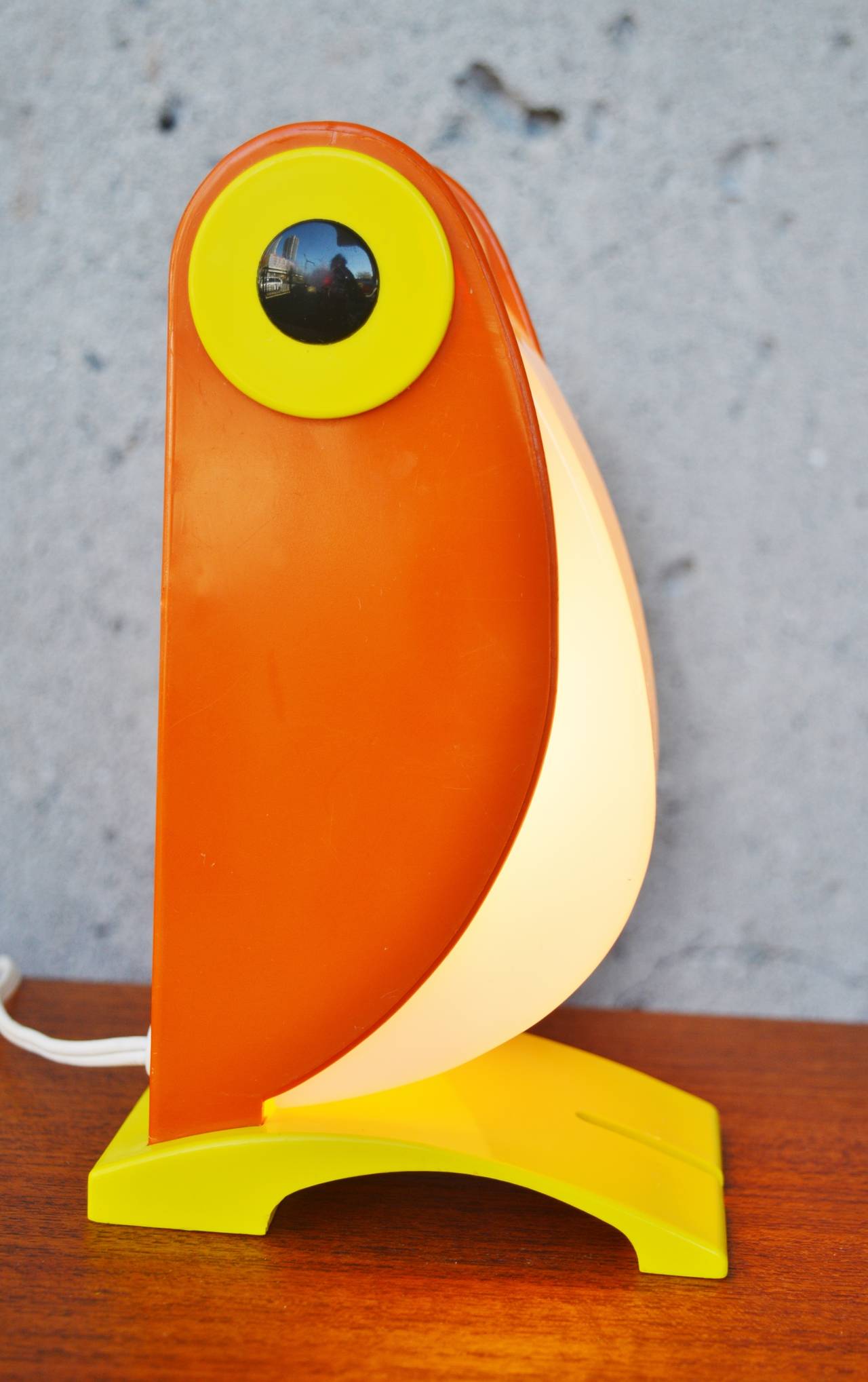 This iconic and charming plastic table lamp in bright orange, yellow and white was manufactured in Italy in the 1970s. Made by Old Timer Ferrari, Verona, Italy, c.1970.  Change the angle of his beak from closed to fully open to alter the amount of