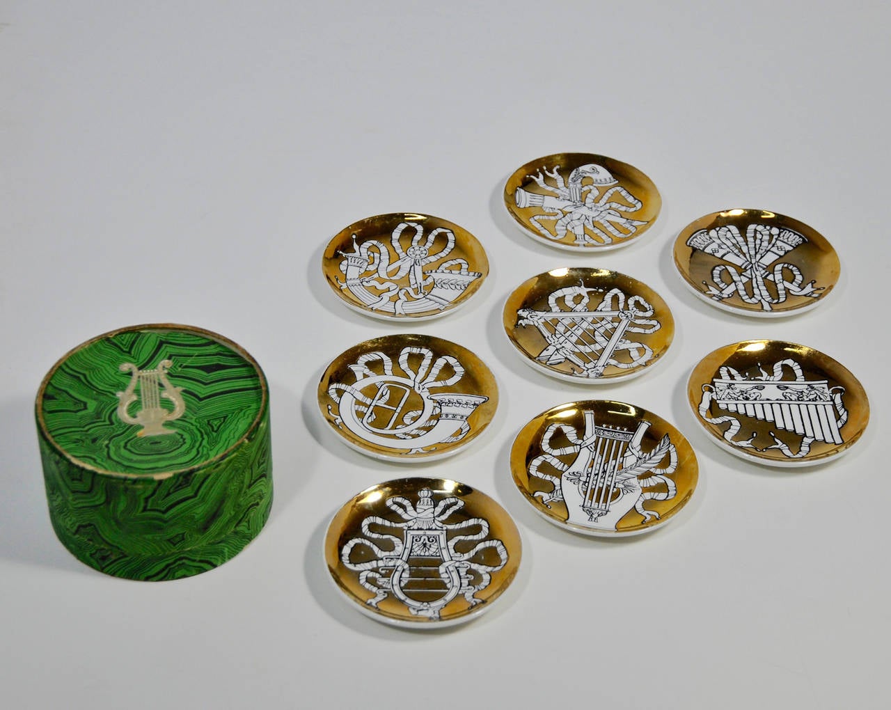 Charming set of Musicalia plates, all different design with this rich gold color.
They are vintage and were made for Bonwit Teller. They have their own box; albeit a bit worn with the Fornasetti hand on the bottom. They have the famous Fornasetti
