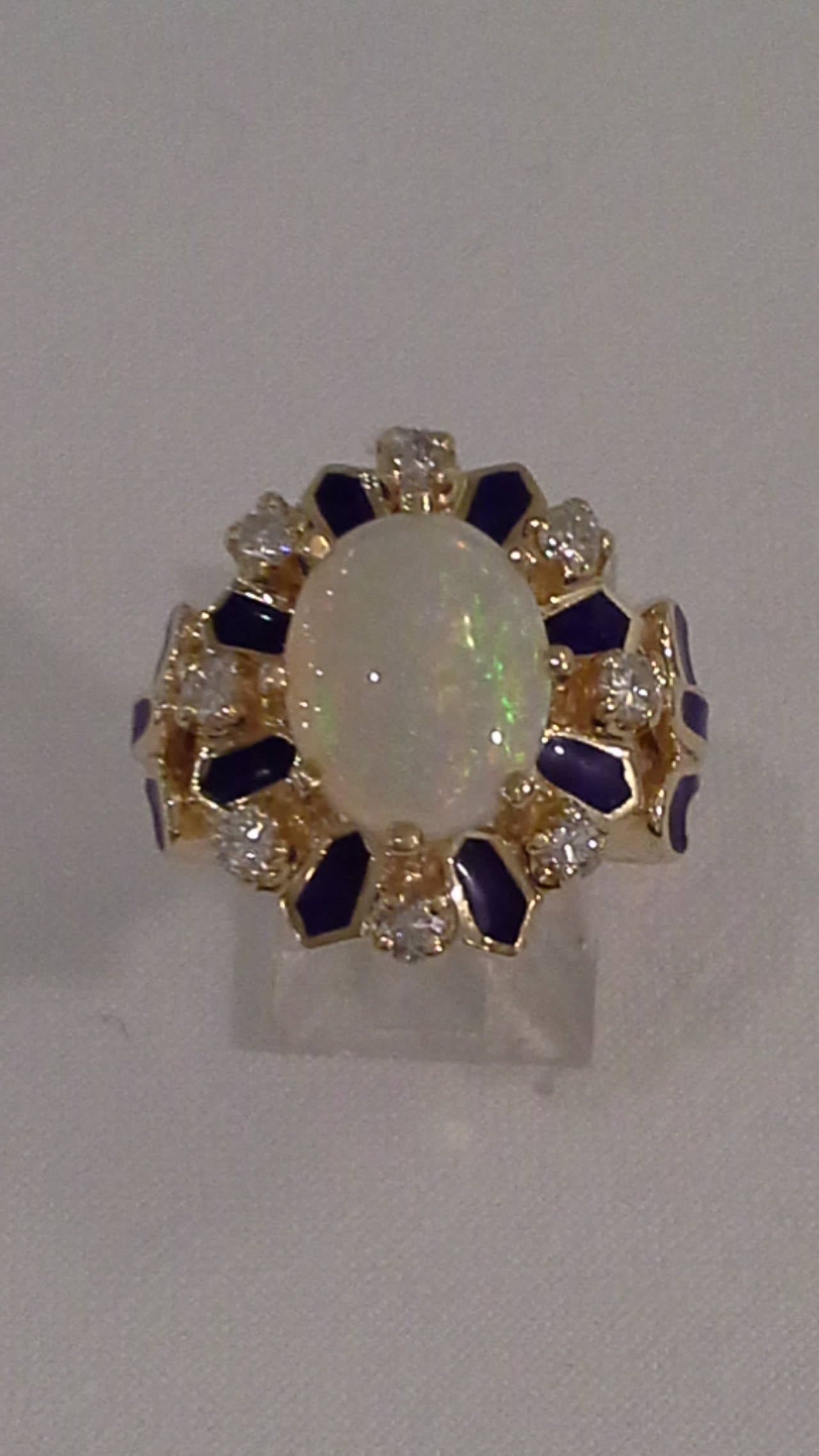 14k Gold, Opal, Diamond & Enamel Cocktail Ring, A nice Ring having a center Fire Opal, surrounded by 8 diamonds and accented with a dark blue enamel. The opal is approximately 2.5 carats, Diamond total is approximately .50 carats, with blue