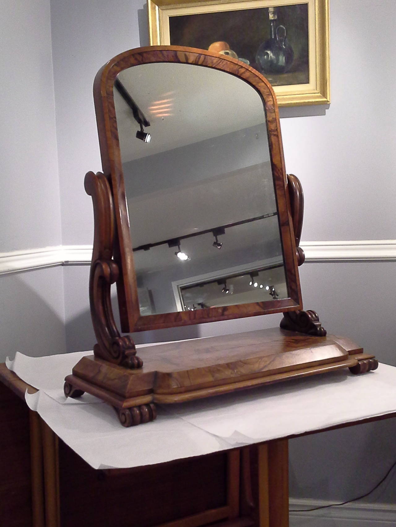 Burled Walnut Gentlemen's Dressing Mirror, On A Scrolled Bun Foot, The mirror is attached to a scrolled support arm and tilts to adjust height, Nice Burled walnut veneer, and patina, There is a light shrinkage split on top of the base, otherwise
