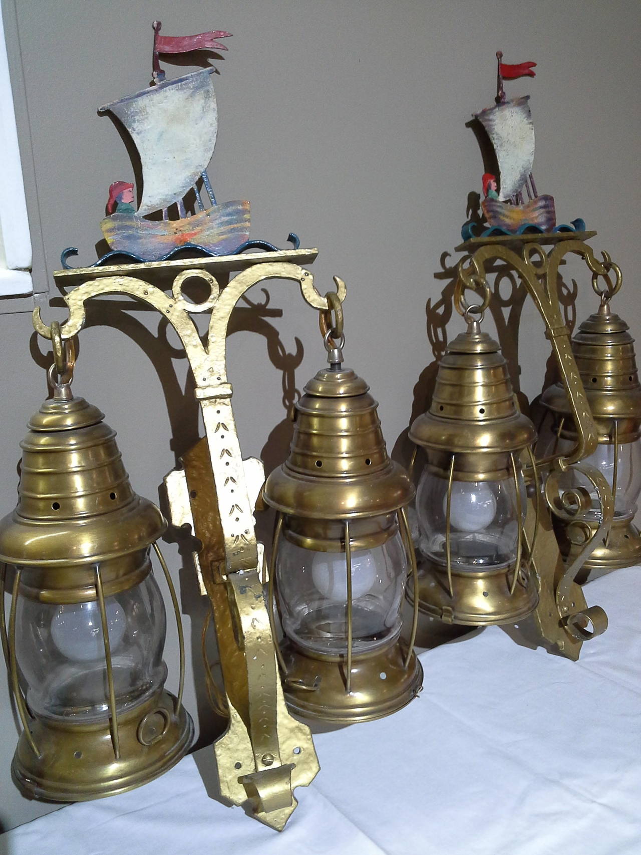 Nautical Lantern Cast Iron Wall Sconces With Sailboat/Fisherman Painted Tops,
Two lanterns on each sconce, glass bottoms for light and to replace bulbs, Cast Iron frames and rewired, the boat and fisherman are painted on both sides. The sconces