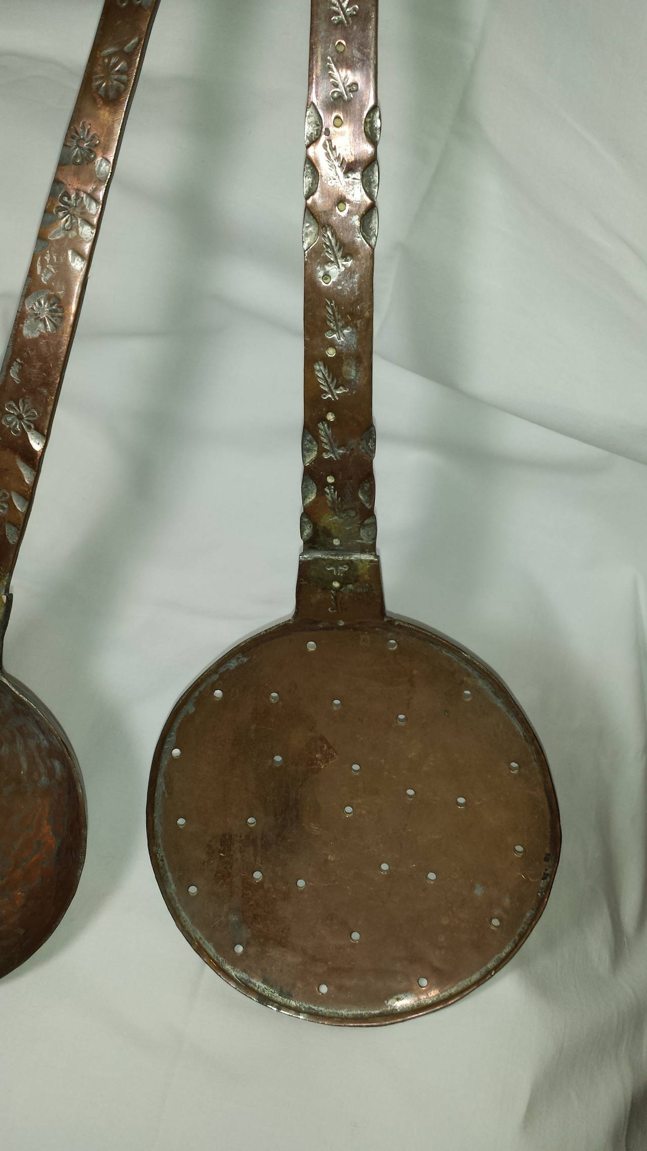 A Pair of Large Copper Cooking Utensils Ladle & Strainer For Fire Place, Hand made and decorated handles, consists of a large strainer and a large ladle, both measure 21 1/2"-inches long and about 6 3/4"-inches wide. Handles are