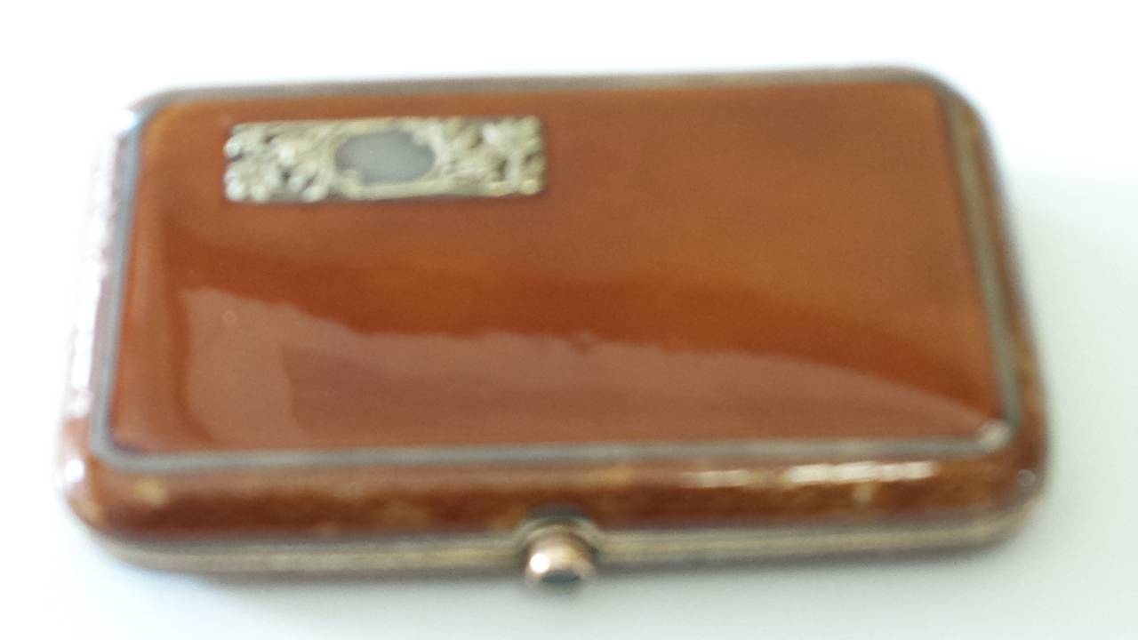 Russian Faberge Enemal Silver Gilt Cigarette Case 14-K Rose Gold Sapphire Button, The case is enamelled in a tan color, and accented on both sides with inlaid silver border, on both sides is a gold intial plate with a silver plaque and has no