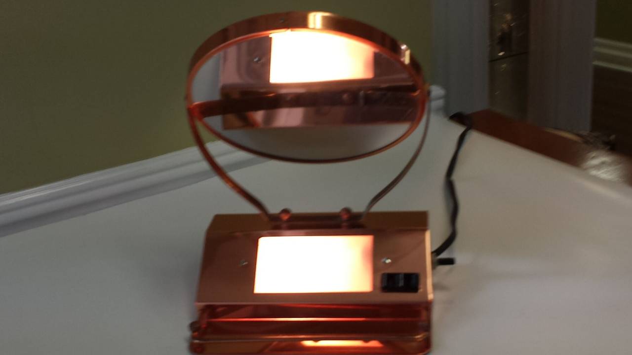 Mid-Century Solid Copper Lighted Vanity Double Sided Mirror With Extra Plug, The mirror flips around and magnifies on one side and regular mirror on the other, front light with a side switch and small front gallery with rail. The mirror measures