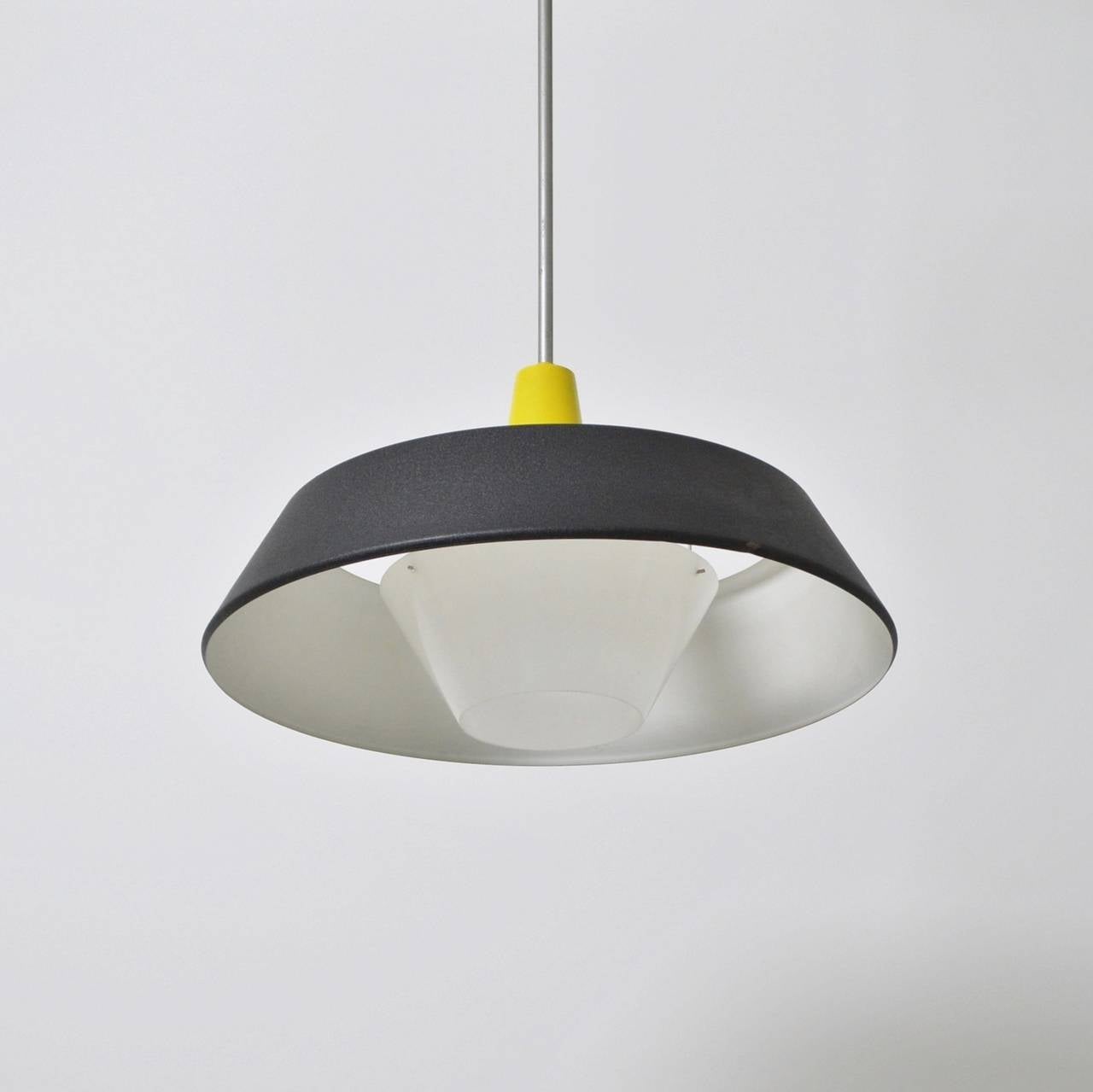 A striking yellow and black fixed ceiling pendant designed by the Philips  lighting design department headed by Louis Kalff. It was produced in Eindhoven by the Netherlands most prestigious electrical manufacturer. The metal hood has a textured