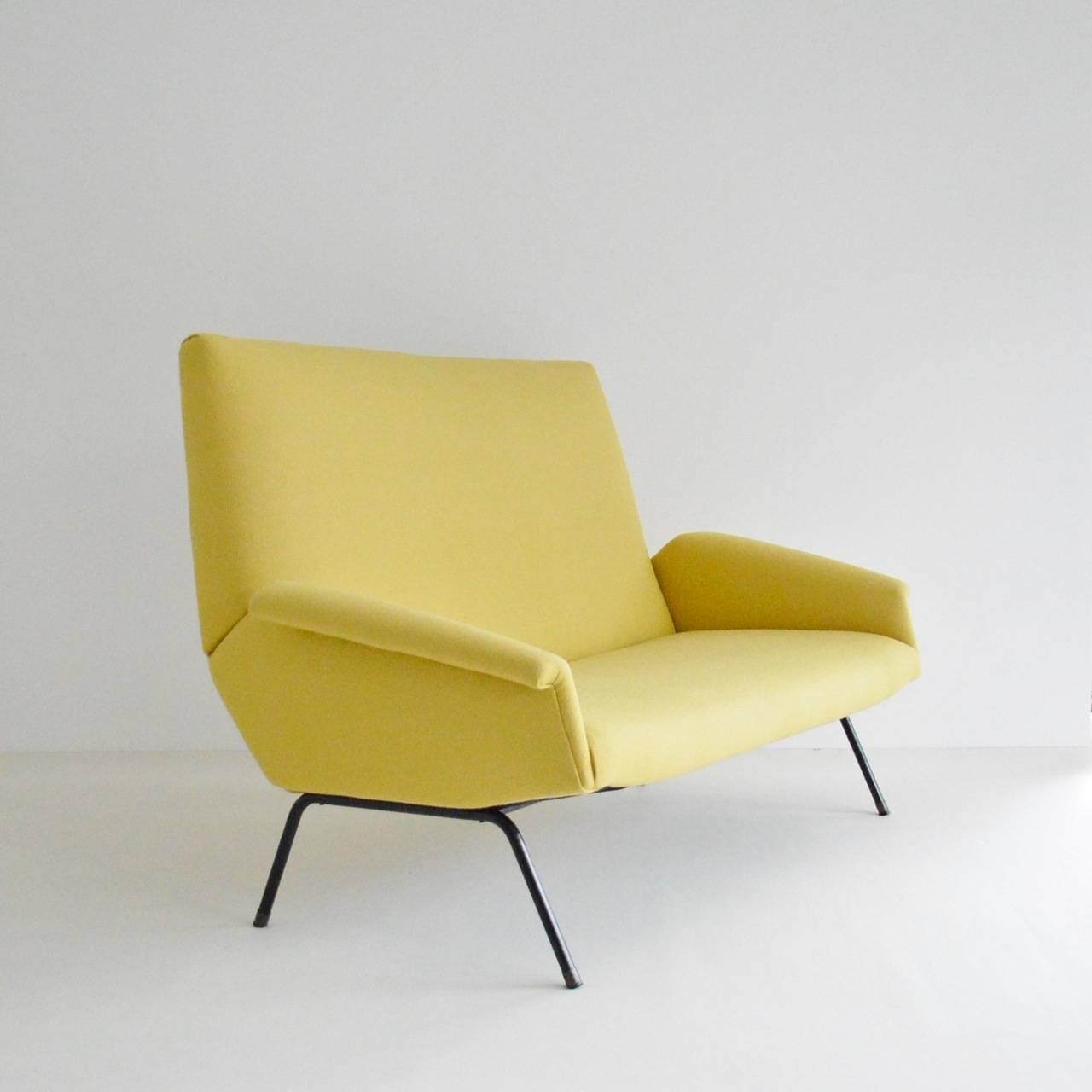 A dynamic modernist two seater sofa attributed to Genevieve Dangles & Christian Defrance. Sitting on a tubular steel base with brass tipped feet the sofa has been recently reupholstered in felted wool Deploeg fabric. Matches with the armchair listed