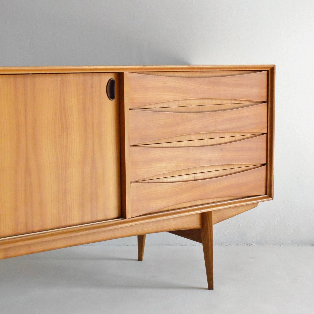 'Paola' cherry wood sideboard by Oswald Vermeacke for Belgian manufacturer, V-Form. A High quality piece with an obvious danish influence. It has an unusual and striking cherry wood veneer with book matched top. Behind the sliding doors there is a