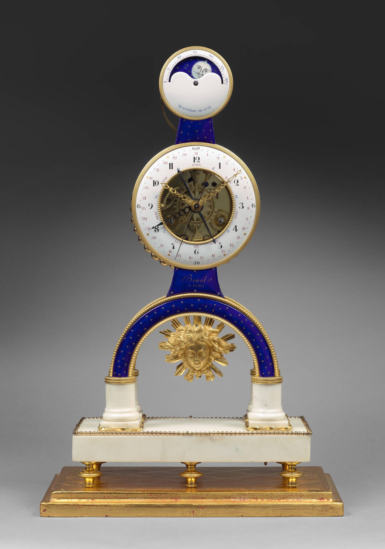 Bruel à Paris 

Gilt Bronze Enamel and Marble Skeleton Clock with Moon Phases
 
Paris, late Louis XVI period, circa 1780 - 85 
Height 50 cm, width 27 cm, depth 12 cm

The main white enamel ring dial, with chased gilt bronze bezel, has black