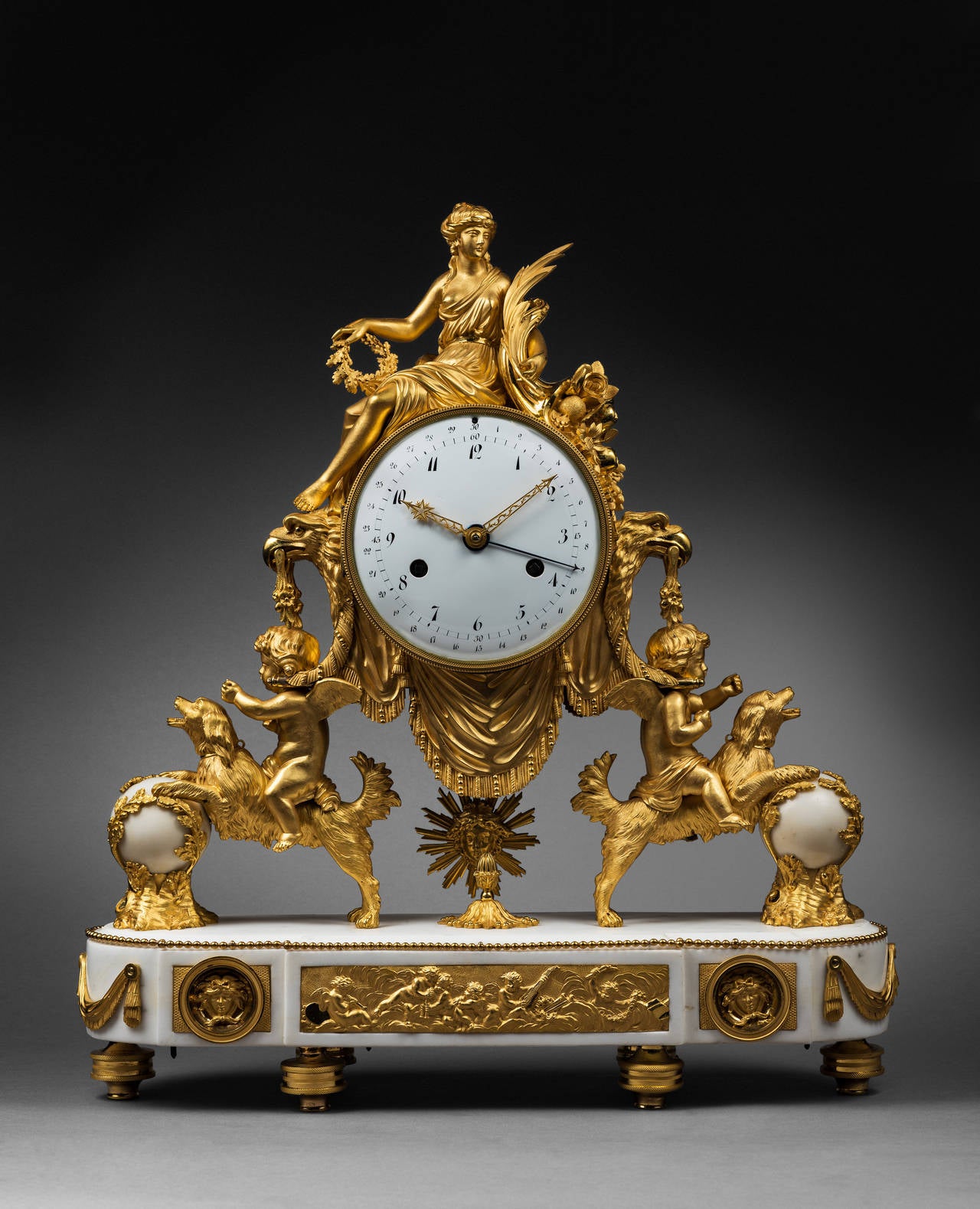 Important Gilt Bronze and Marble Mantel Clock

Paris, late Louis XVI period, circa 1785-1790
Height 53.5 cm; width 50 cm; depth 13.5 cm

The round enamel dial indicates the hours in Arabic numerals and the fifteen-minute intervals by means of