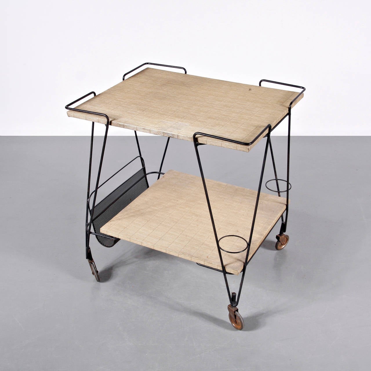 Tea trolley designed by Mathieu Matégot.
Manufactured by Ateliers Matégot (France), circa 1950.
Folded, perforated metal lacquered in black and brass detail.

In good original condition, with minor wear consistent with age and use, preserving a