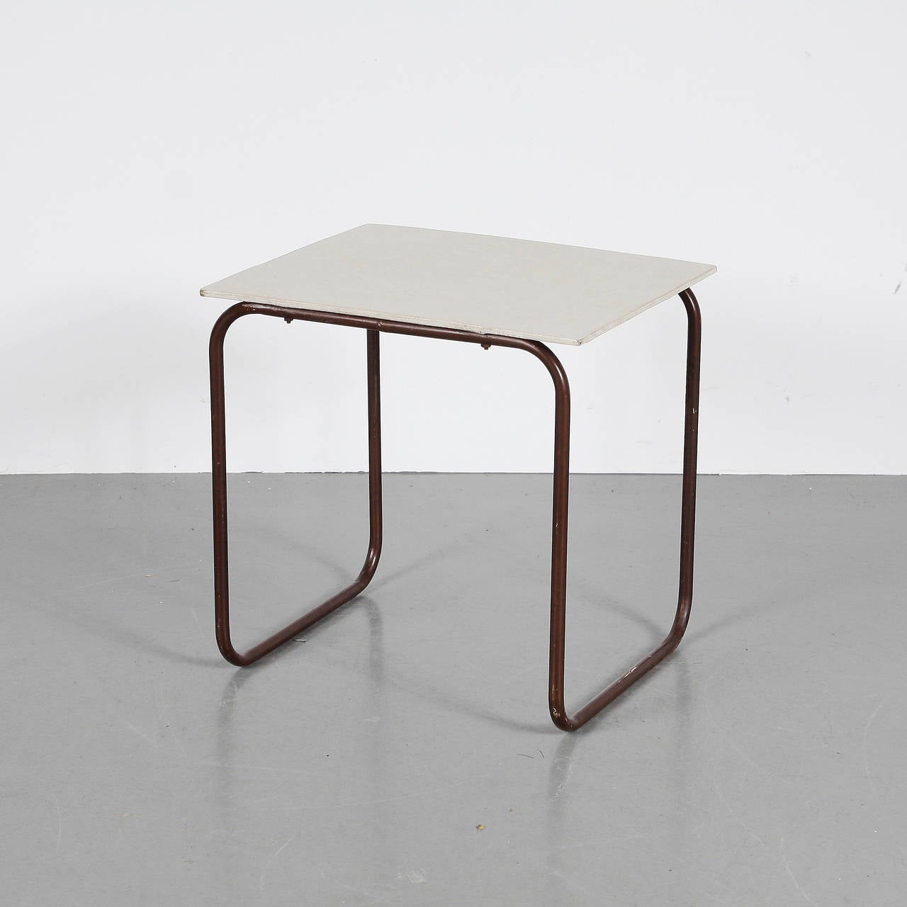 Side table manufactured in the Netherlands, circa 1950.
Lacquered wood top in original condition with tubular metal frame.

We offer free shipping for this piece.