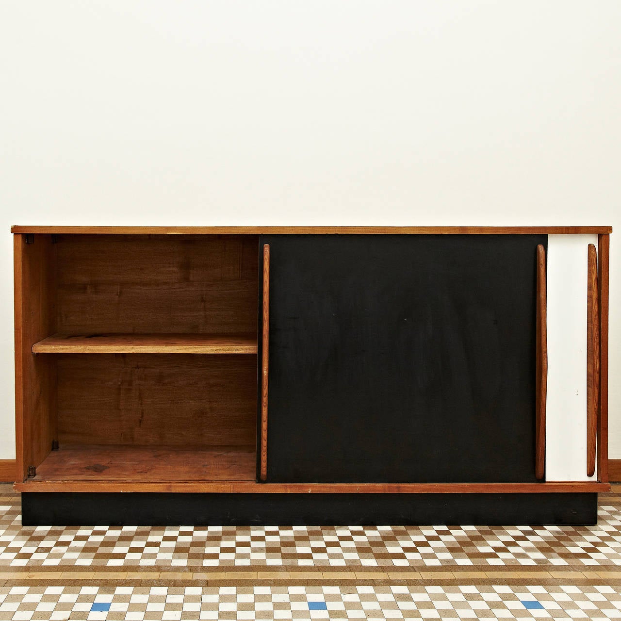 Sideboard designed by Charlotte Perriand, circa 1950. 
Edited by Steph Simon (France). 
Steel base, wood structure and grips, lacquered sliding doors. 

Provenance: Cansado, Mauritania (Africa).

In good original condition, with minor wear
