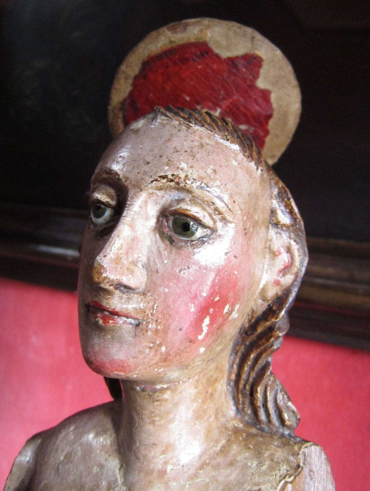 This polychromed statue is from 18th C. New Spain, now Mexico.  The glass eyes help project the saintly facial expression, that is representative of the colonial period.  Much of the original paint remains, most importantly on the face.  It was made