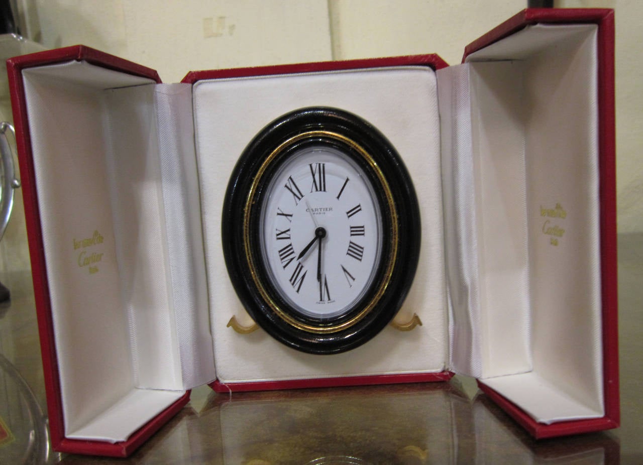 This lovely little Cartier clock, known as the Pendulette has not been used much.  Still keeping perfect time.  The paperwork shows it was purchased in Paris on May 21, 1979.
The box is in excellent condition still and the only visible defect to