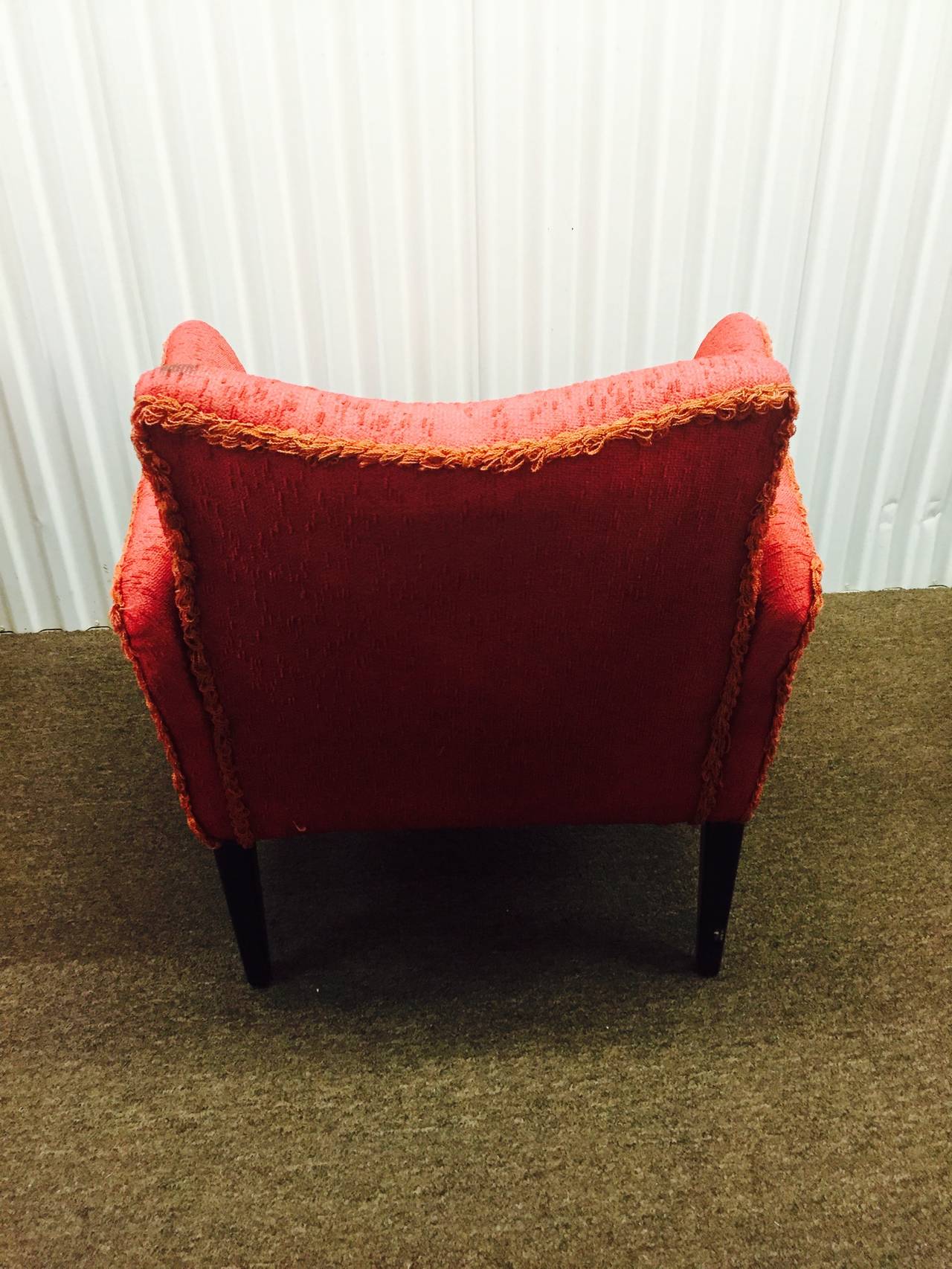 A vintage circa 1960s pair of red Italian club chairs with winged arms and ebonized wooden bases. Good vintage condition. In the manner of. Rob John gibbings. 