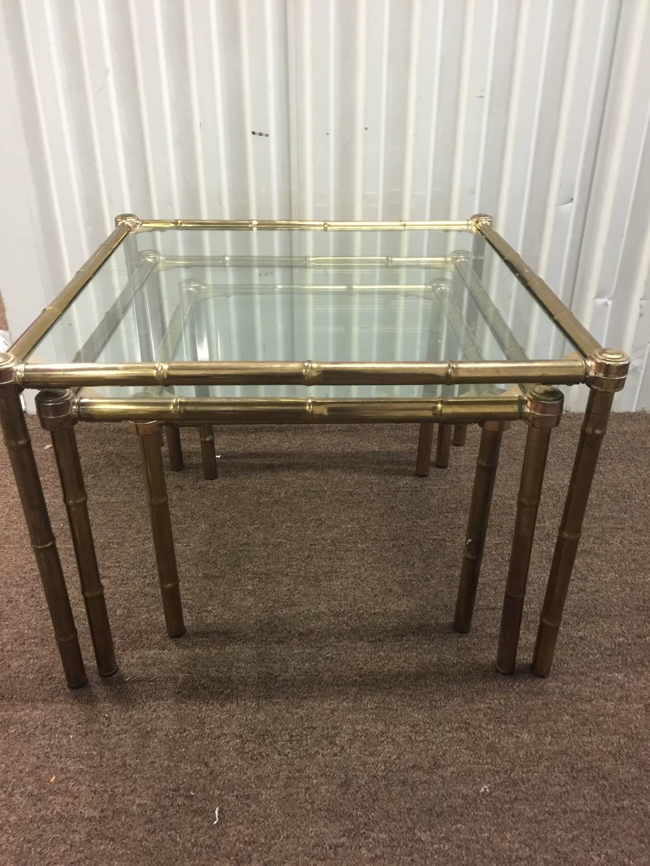 A vintage 1960s set of three unusually thick brass Italian nesting tables with glass tops. Good vintage condition with age appropriate patina.

Measures: Large table 16
