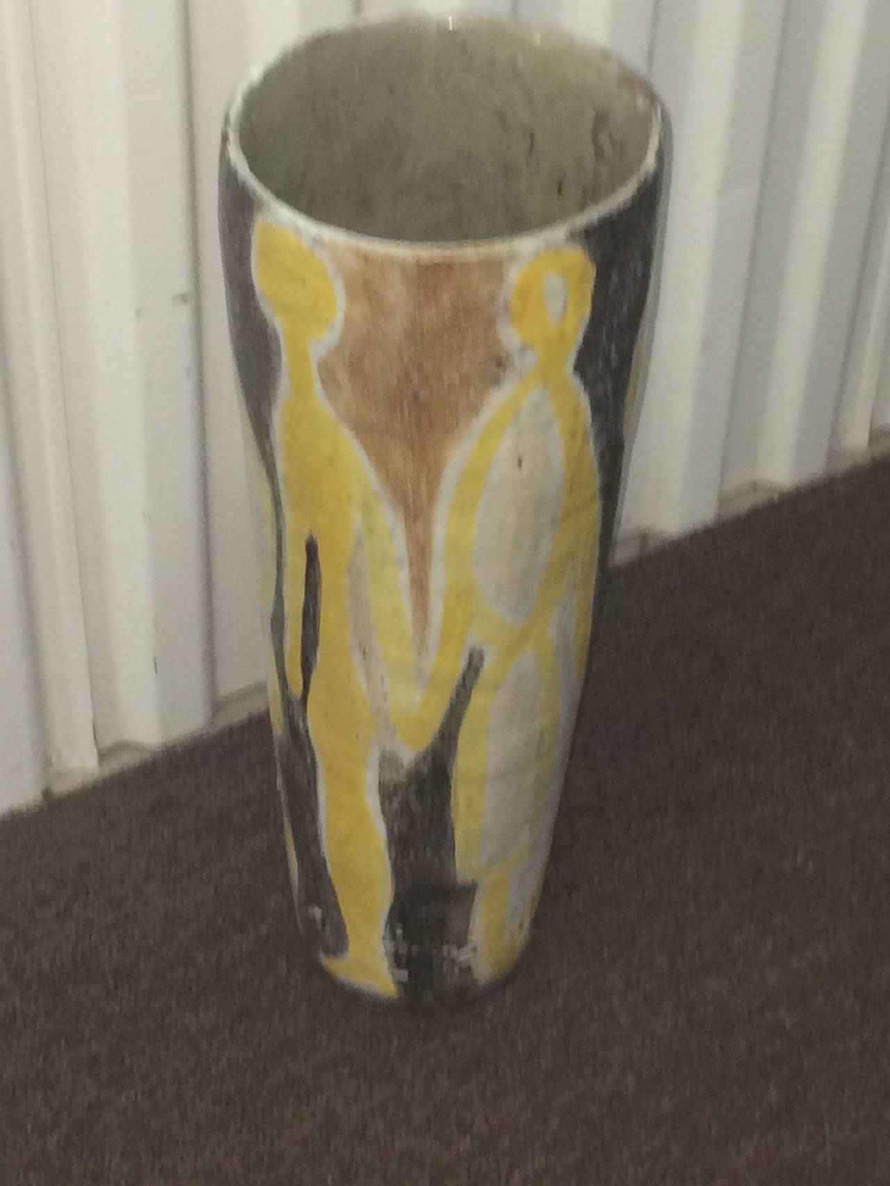 A vintage 1950s terra cotta pottery vase with abstract figures in oatmeal, yellow, and burnt sugar glaze by master potter Guido Gambone. This combination of color is one he used frequently. His signature is smeared under the base. Good vintage