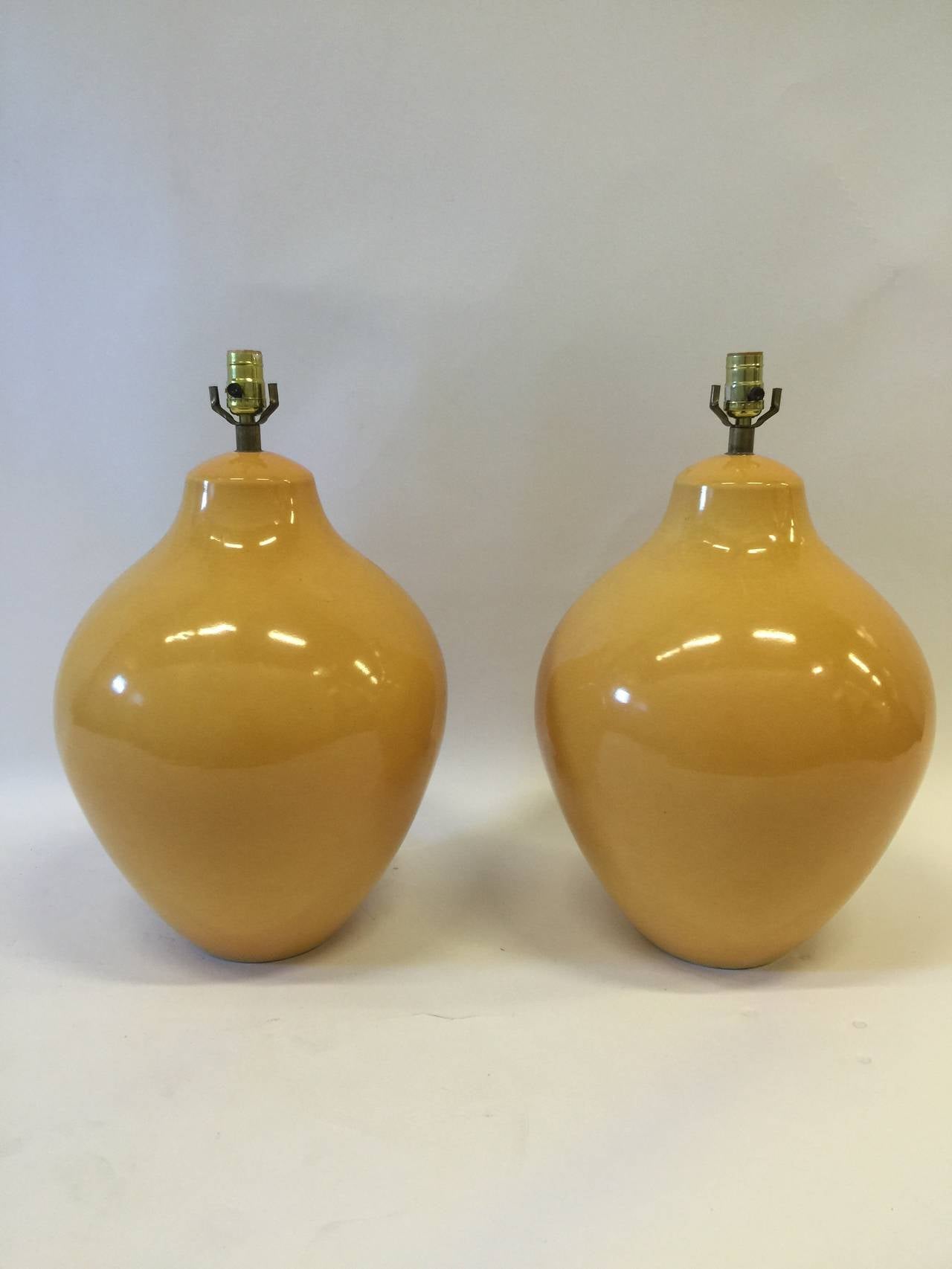 Here is a pair of glazed yellow ceramic lamps in an large form ovoid design. Designed in the 1970s these are a colorful and elegant pair of lamps that can accent many decors in very good shape.